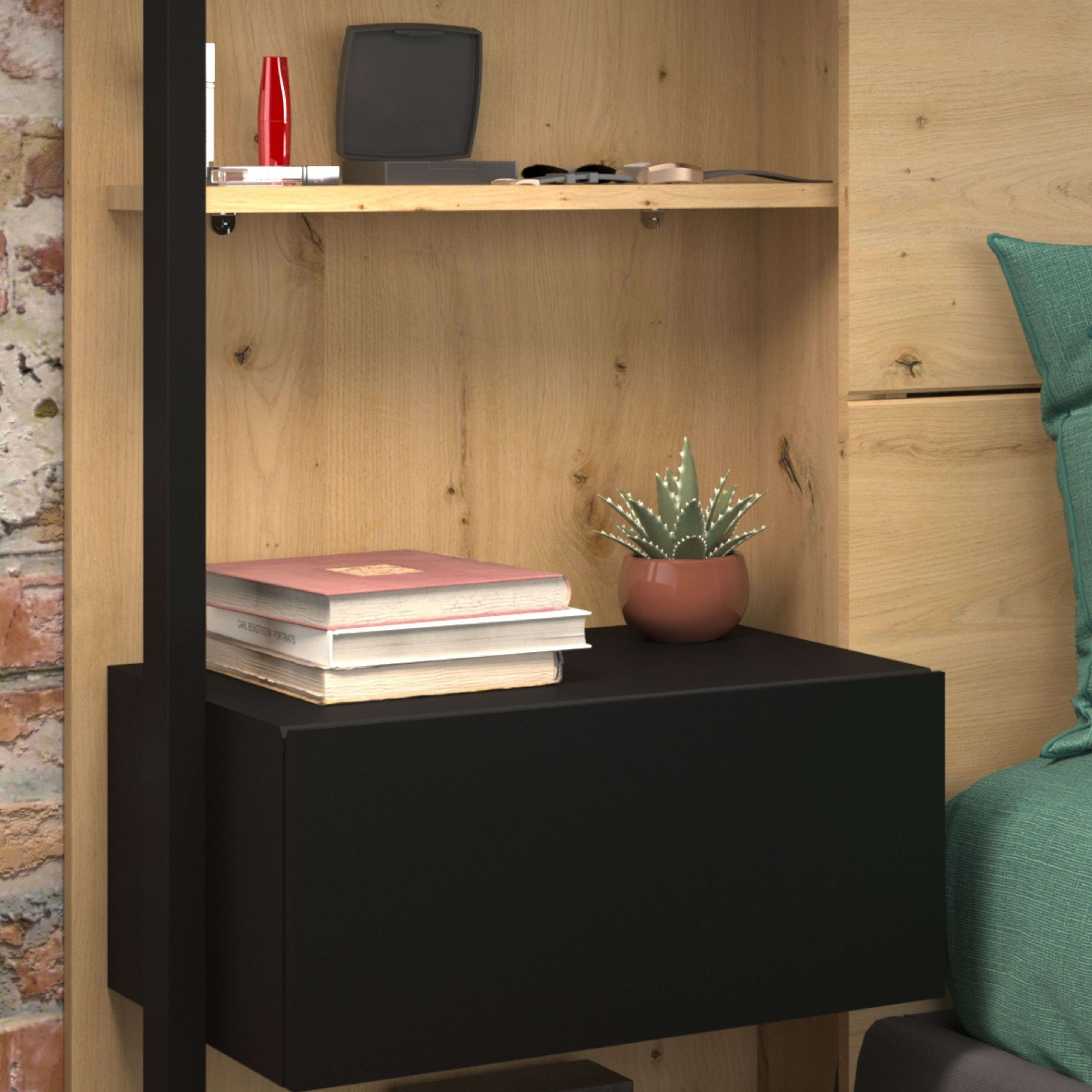 Libros y una planta en una mesita de noche negra junto a una cama de madera.