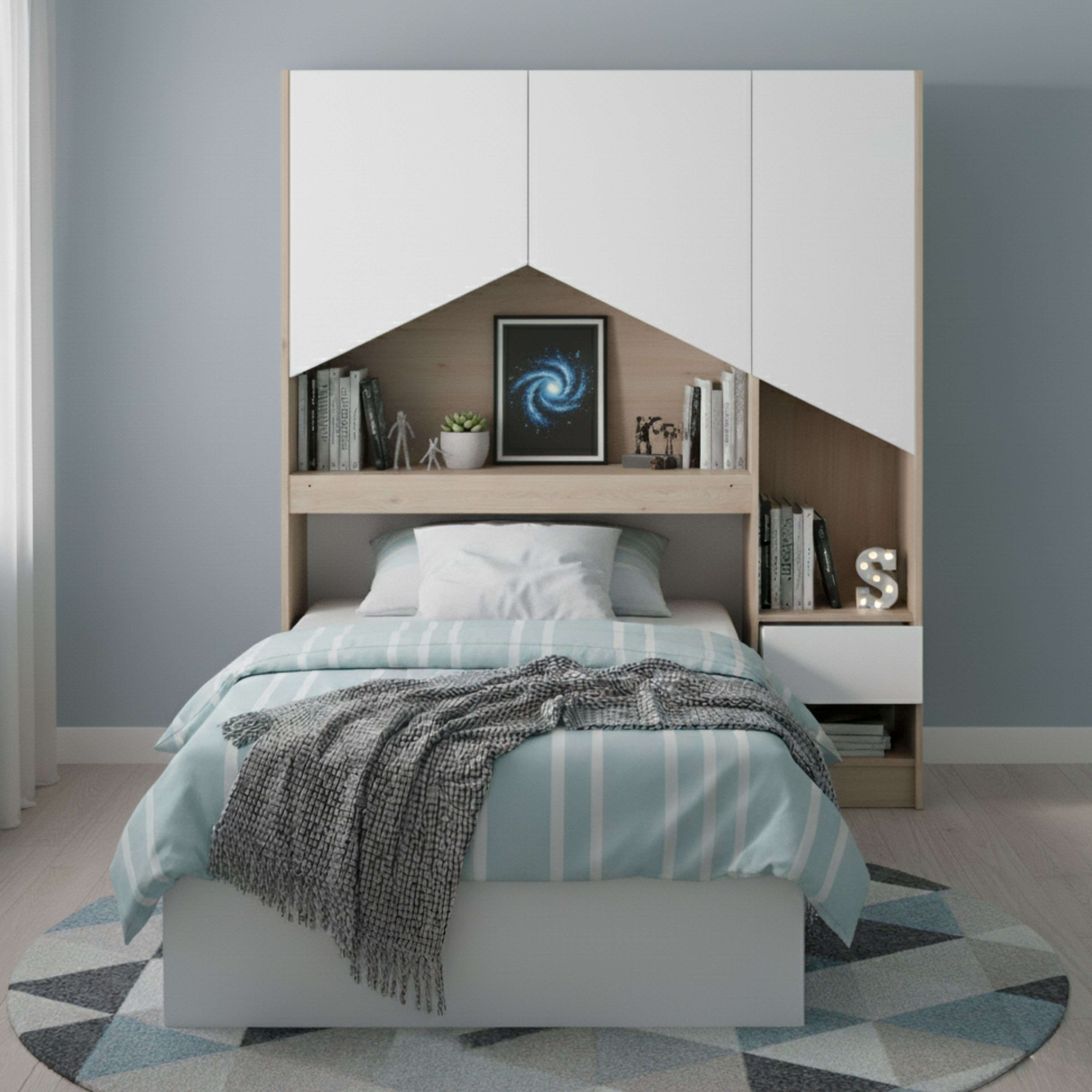 Una cama con ropa de cama azul y blanca, una manta y una mesita de noche.