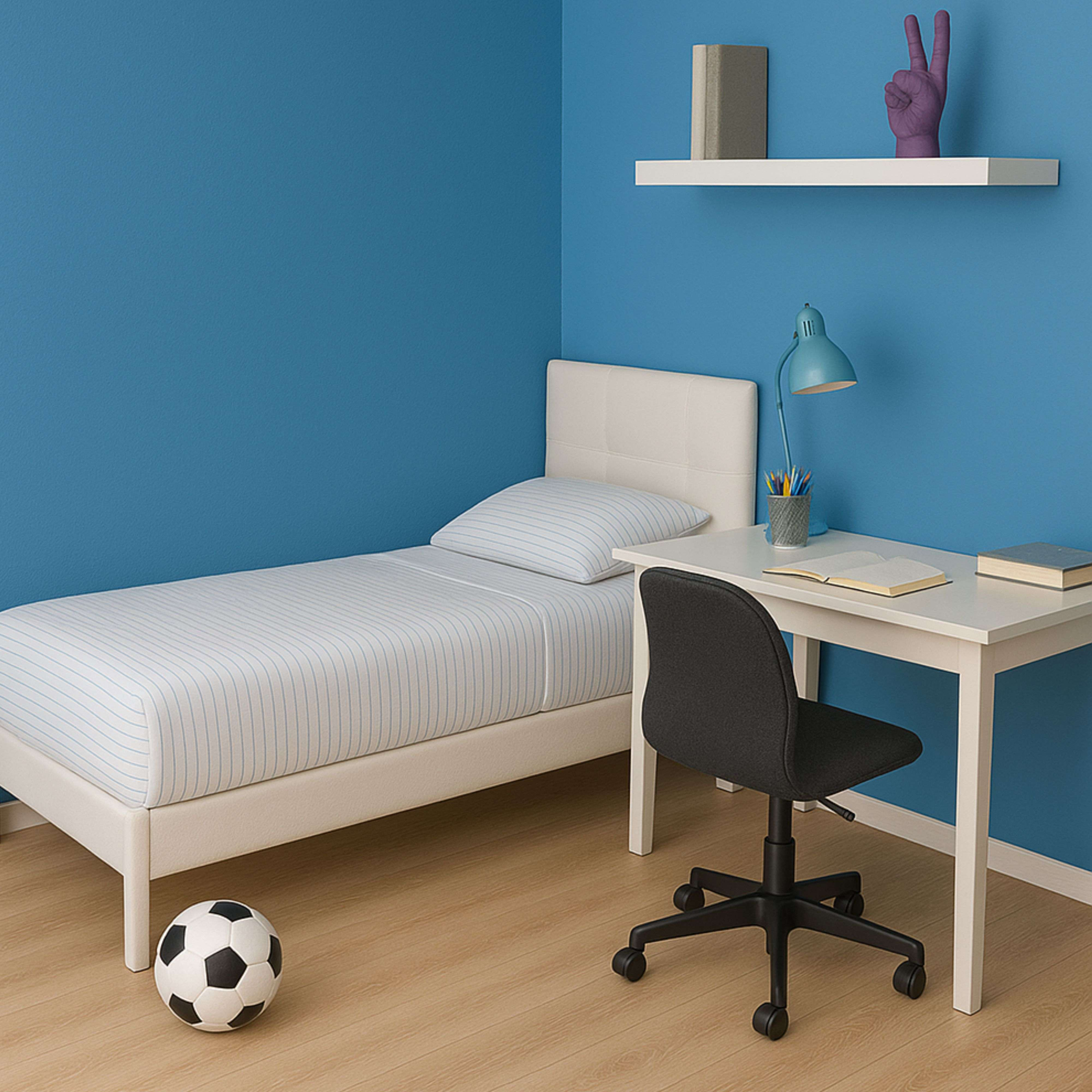 Una cama, un escritorio con silla y un balón de fútbol en una habitación azul.