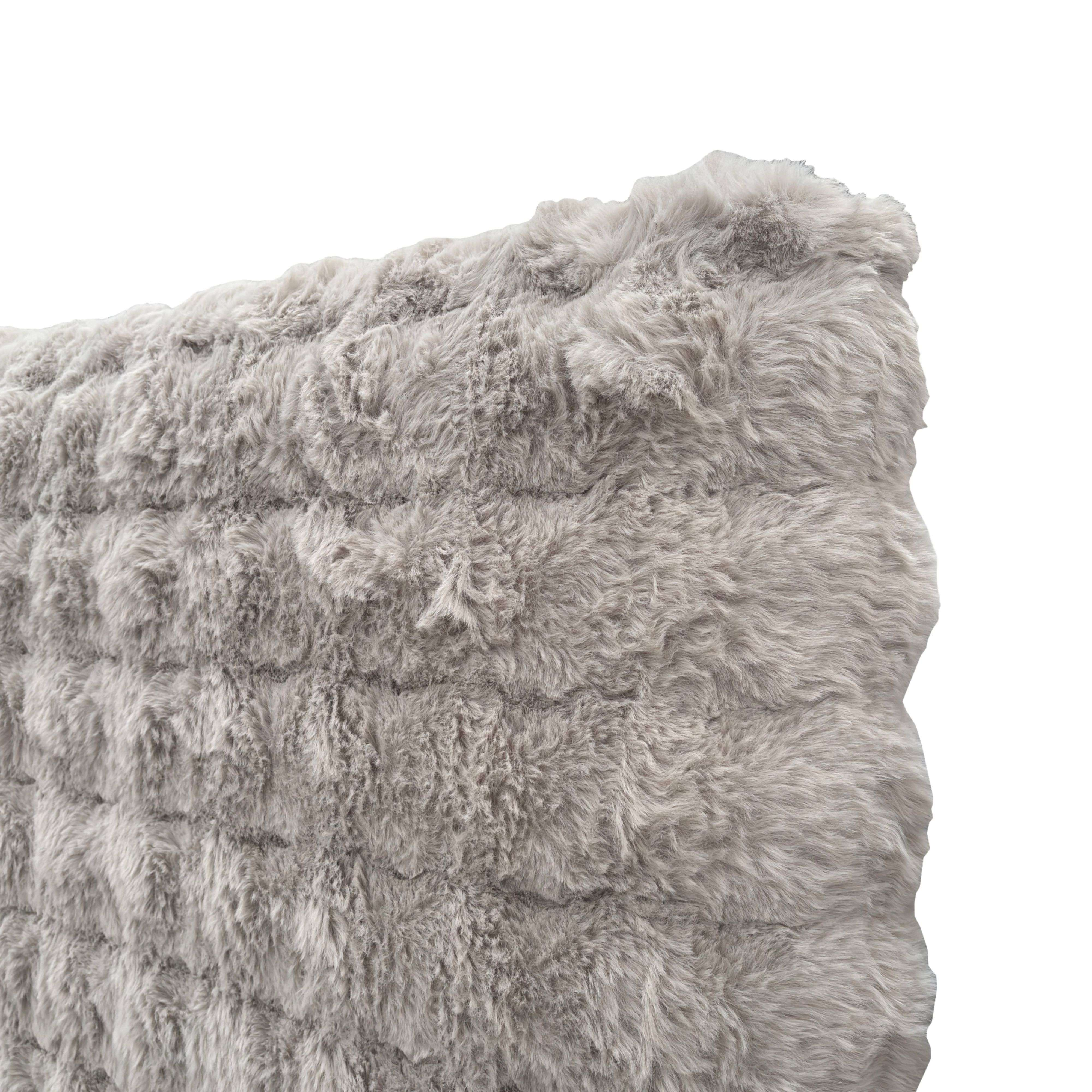 Tela gris de pelo sintético y esponjoso con textura y ondas visibles.