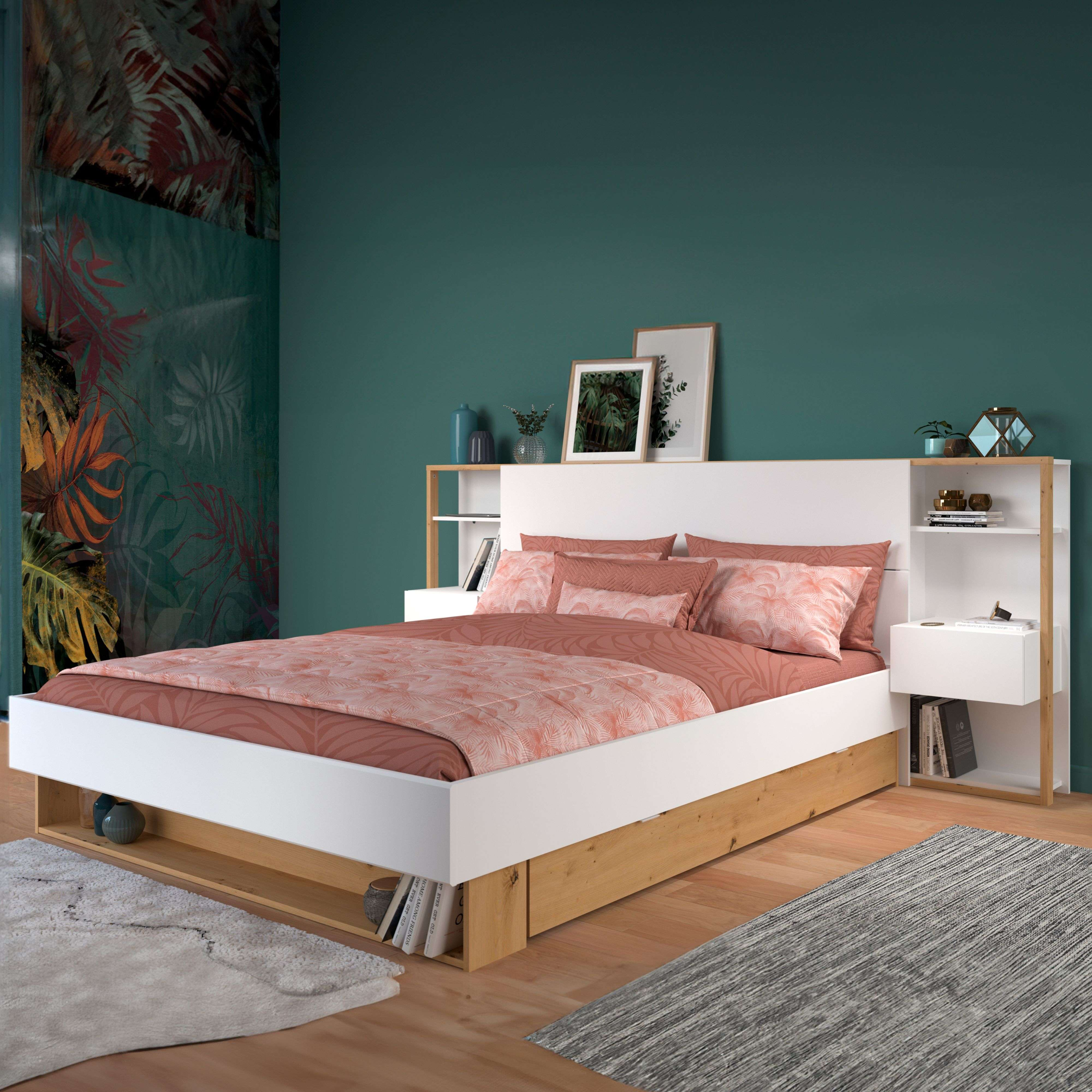 Un dormitorio moderno con cama blanca, sábanas de hojas, mesitas de noche y alfombras.