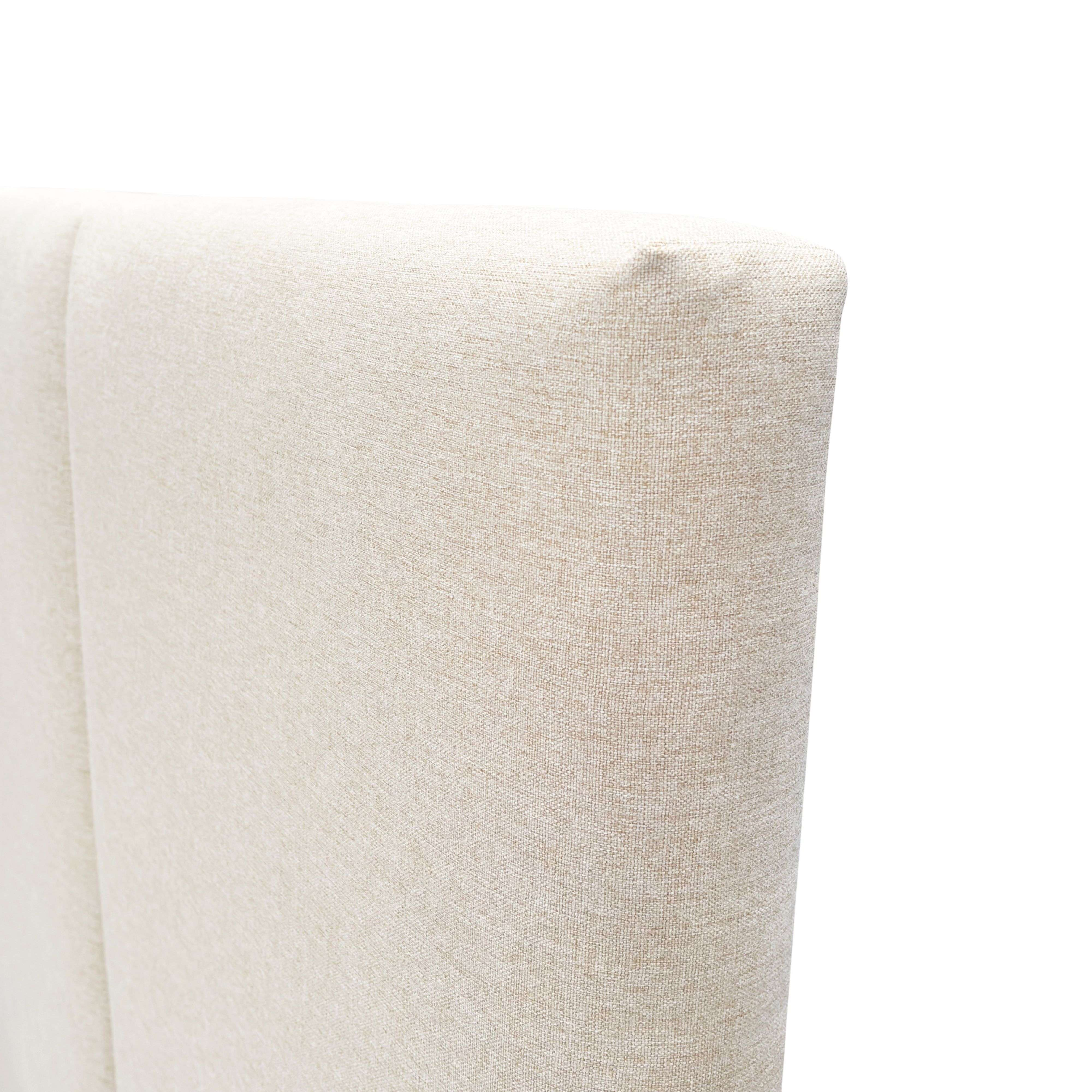 Tapicería beige de un mueble con textura de tela.