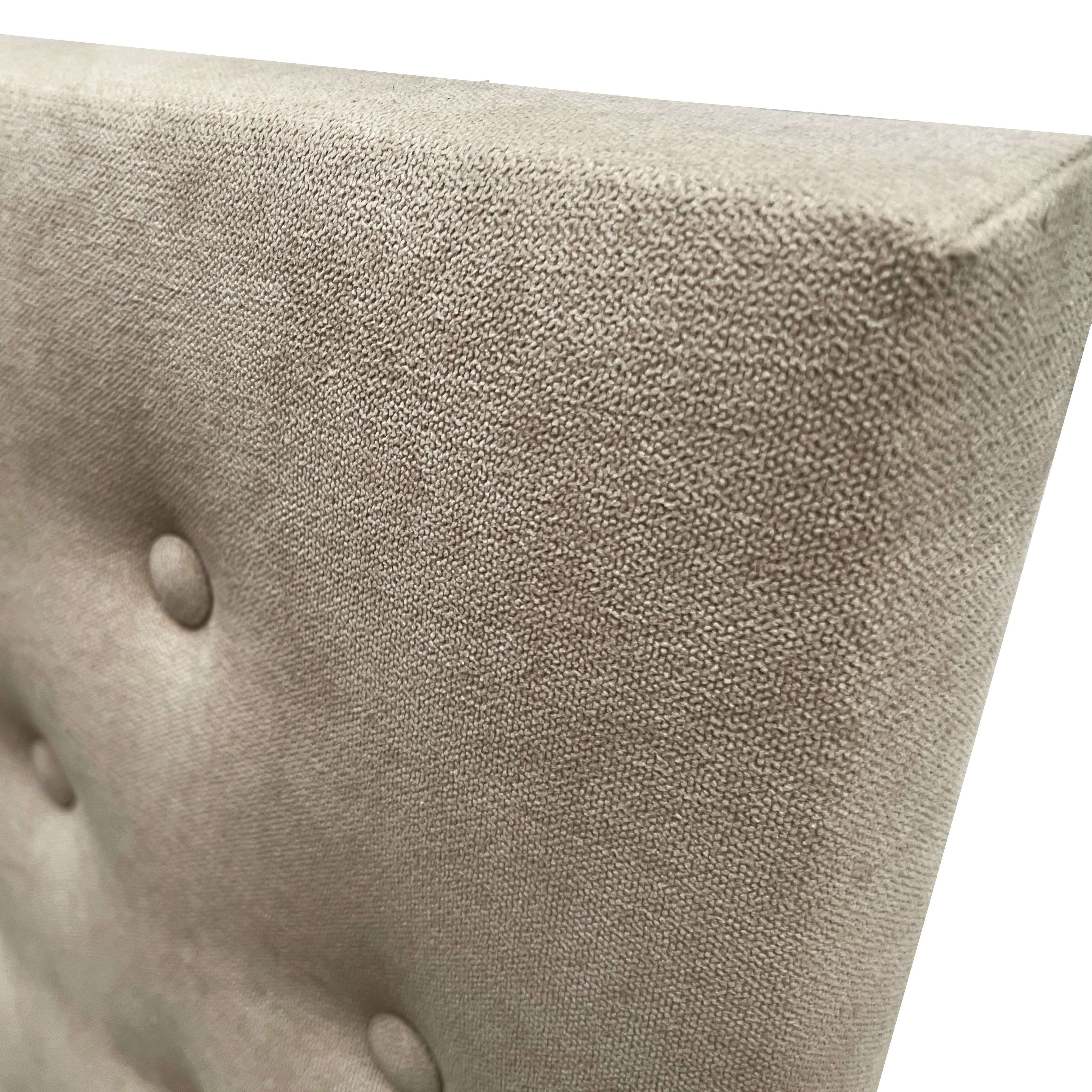 Primer plano de tela beige con tapicería de botones en muebles.