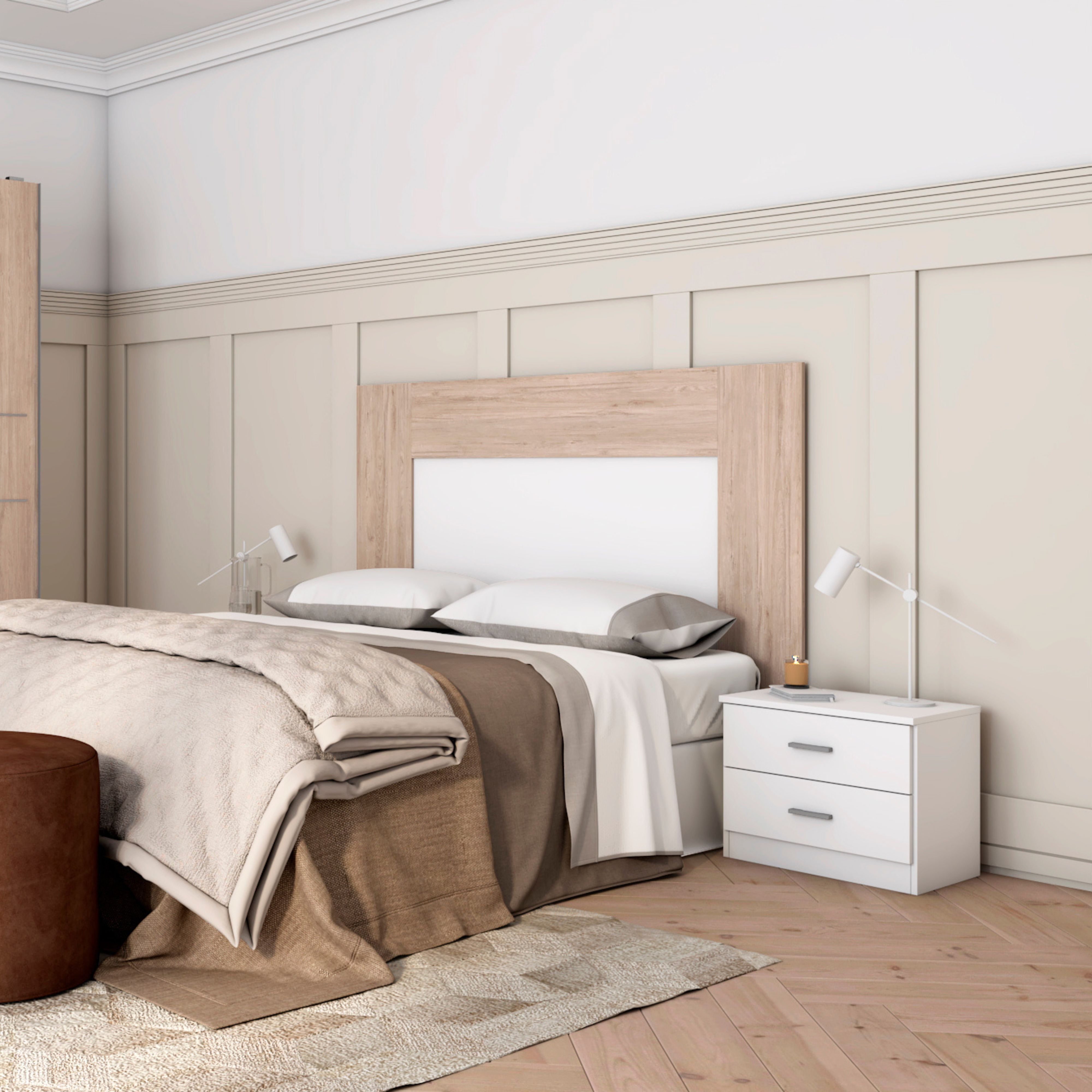 Una cama con ropa de cama beige, mesita de noche y lámpara.