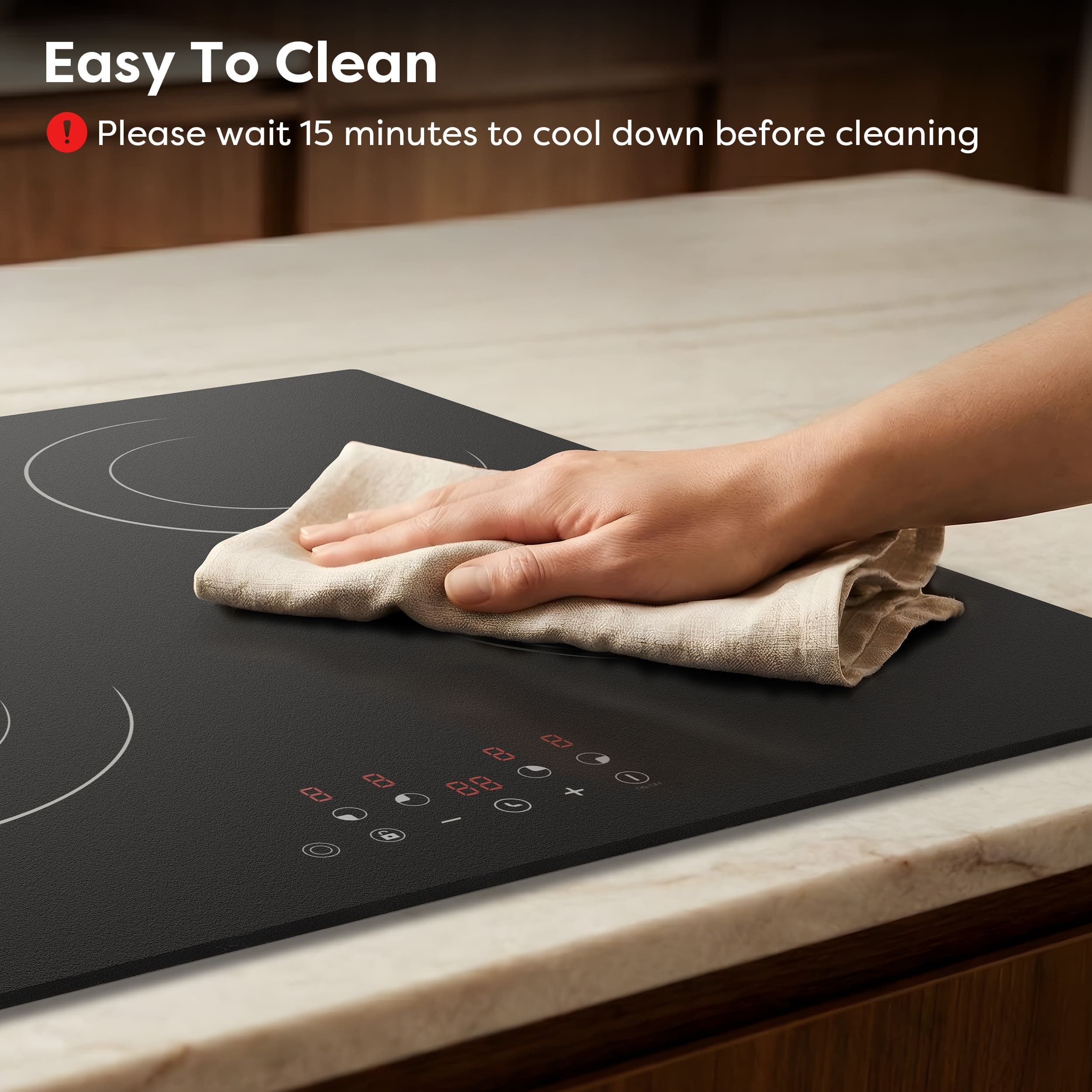 A hand wipes a black induction cooktop with digital controls.