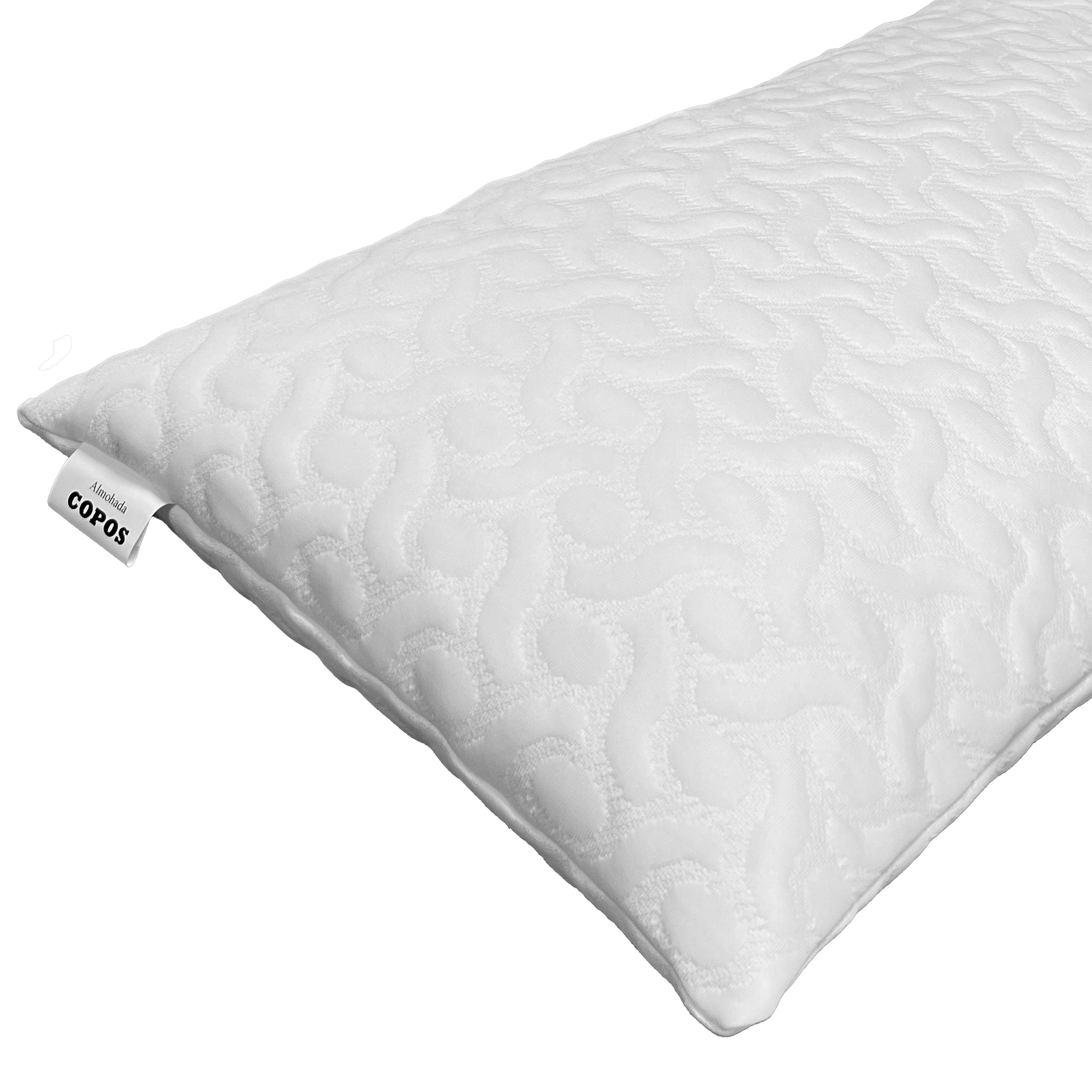 Una almohada blanca con un patrón y una etiqueta que dice COPOS.