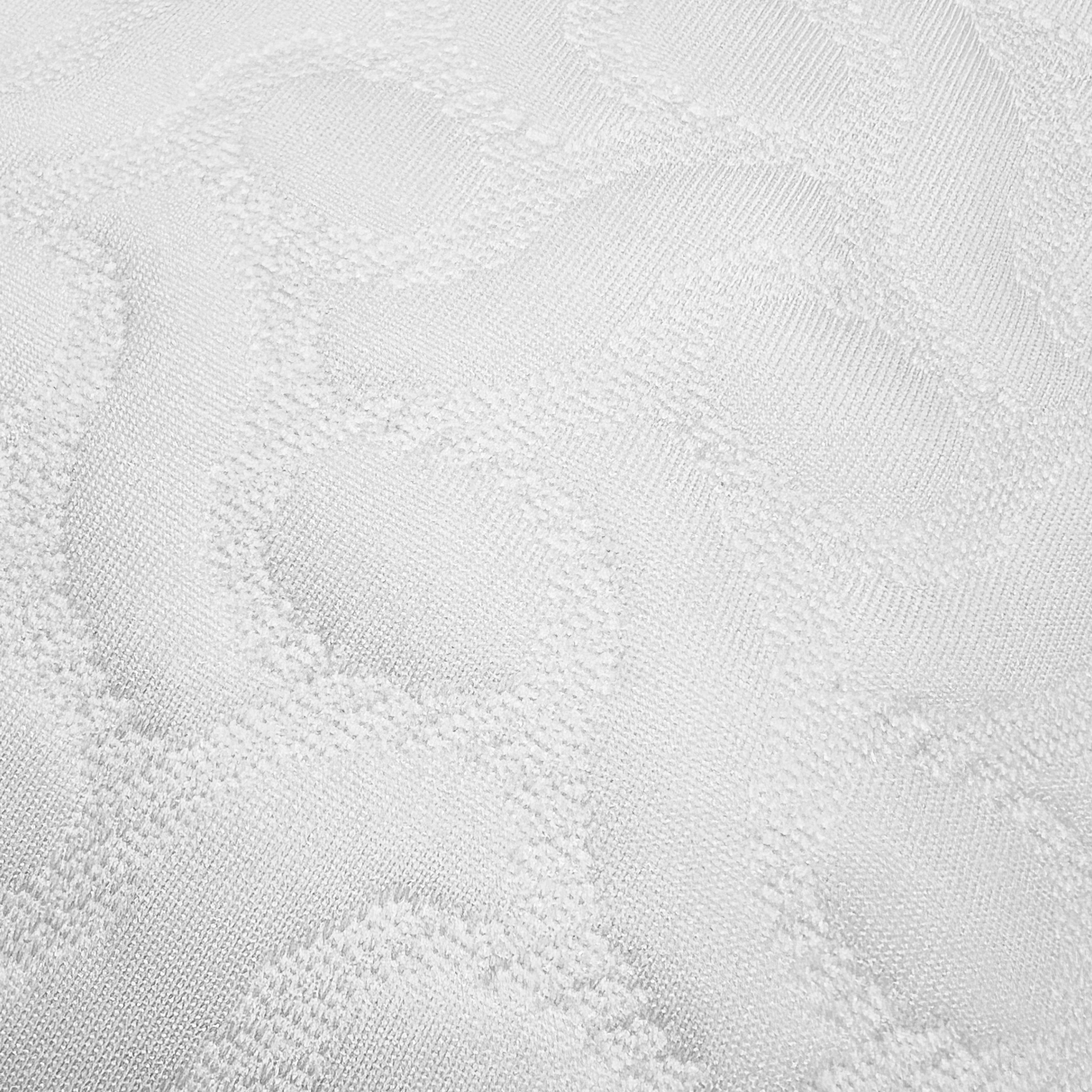 Primer plano de tela blanca texturizada con un patrón repetitivo.