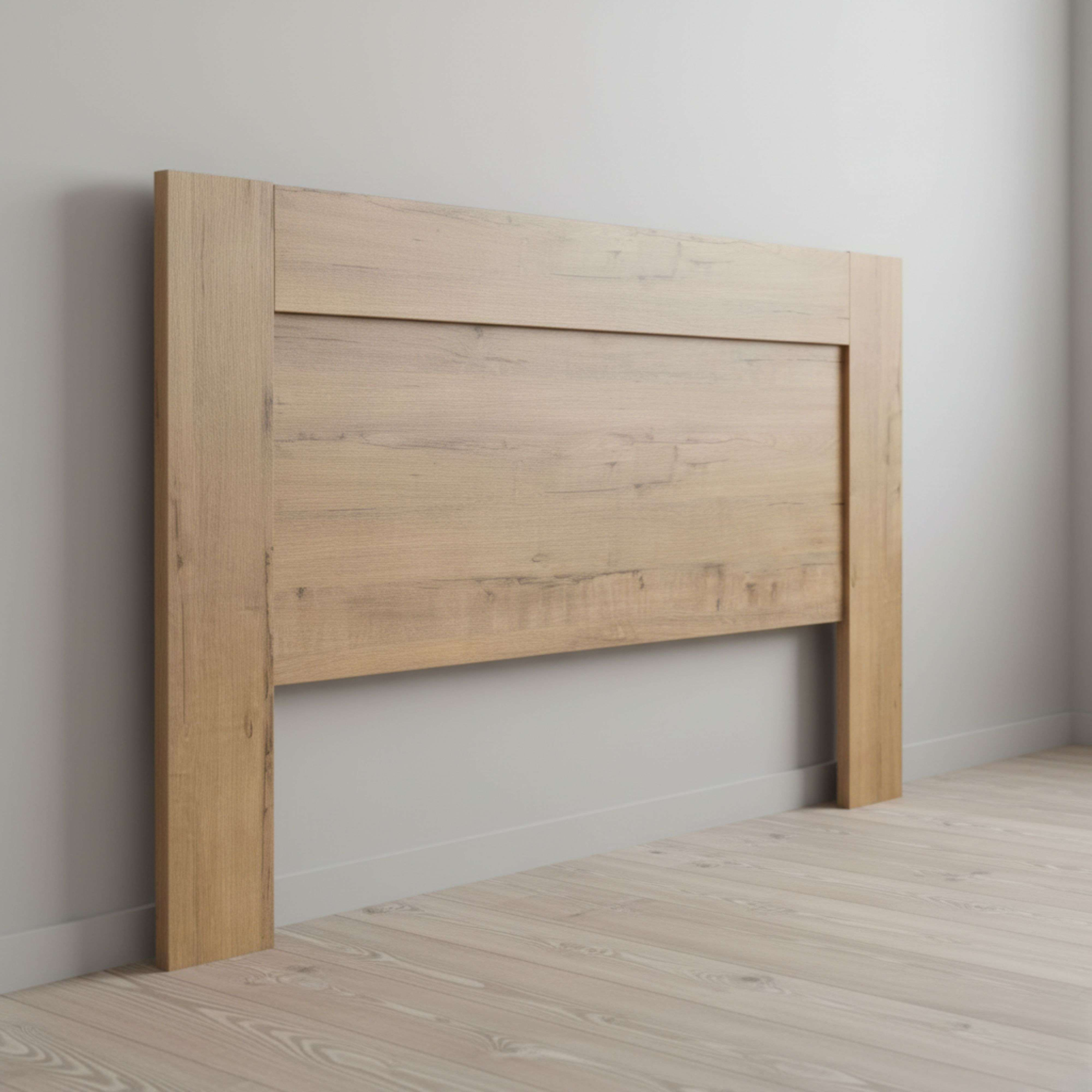 Una cabecera de madera apoyada en una pared sobre suelo de madera.