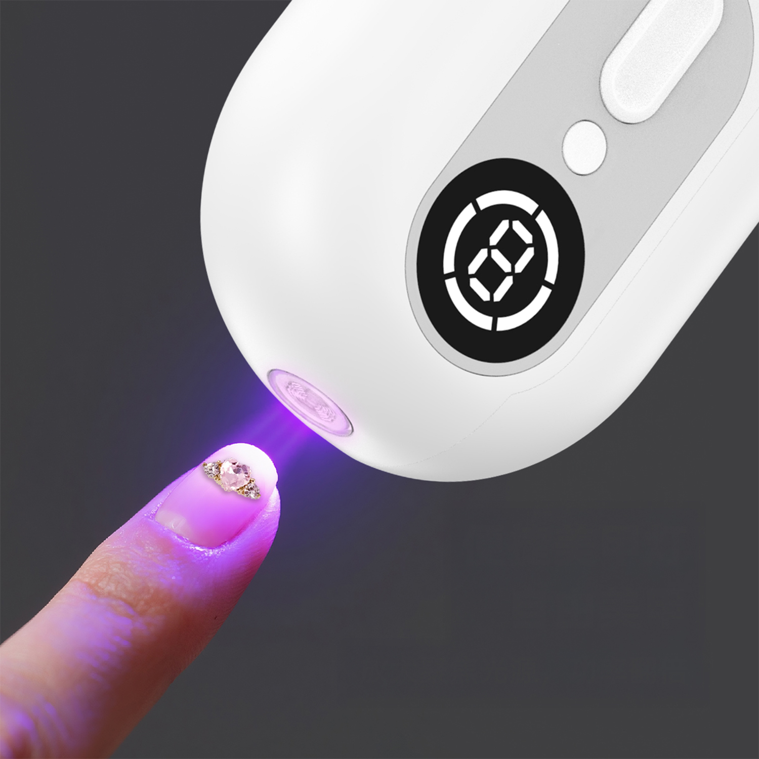 Una mano cura un'unghia decorata con luce UV.