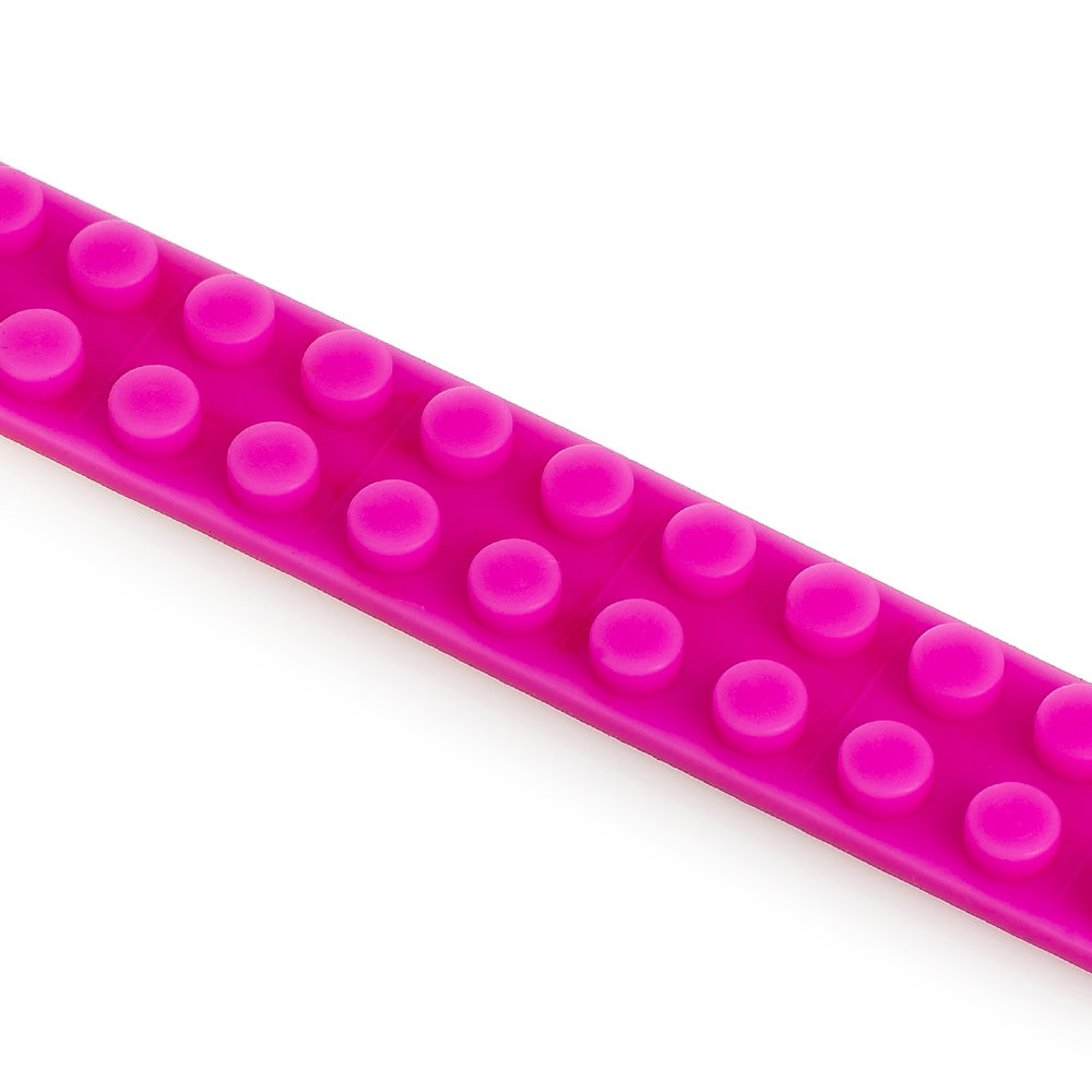 Primer plano de un riel flexible de color rosa brillante con protuberancias, similar a bloques de construcción.