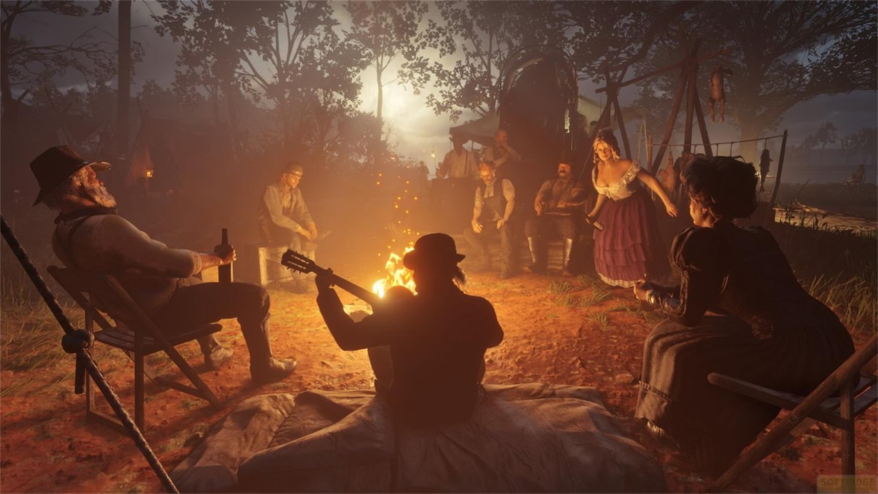 Een groep mensen zit rond een kampvuur, een speelt gitaar.