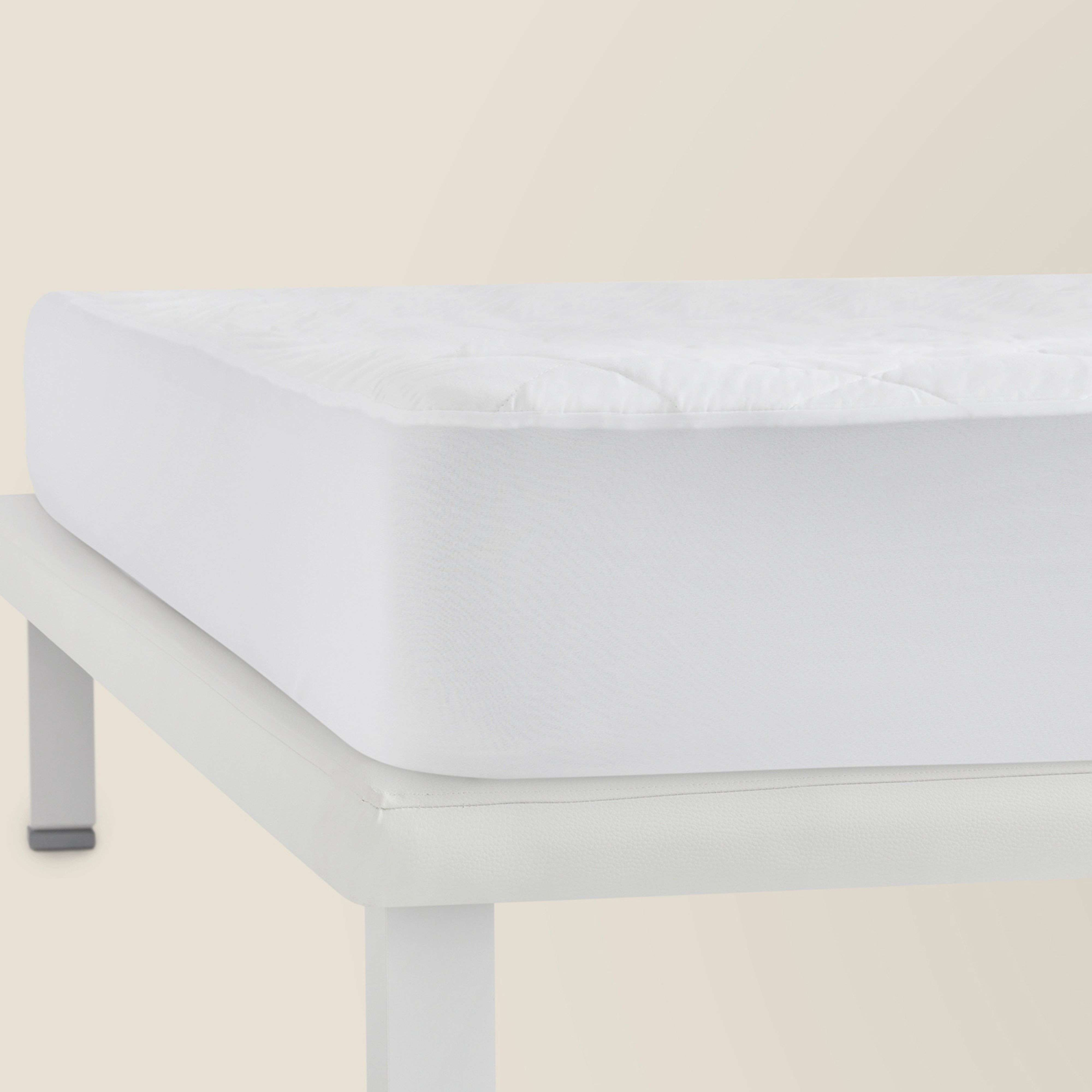 Un colchón blanco acolchado sobre una base de cama blanca. Diseño simple.