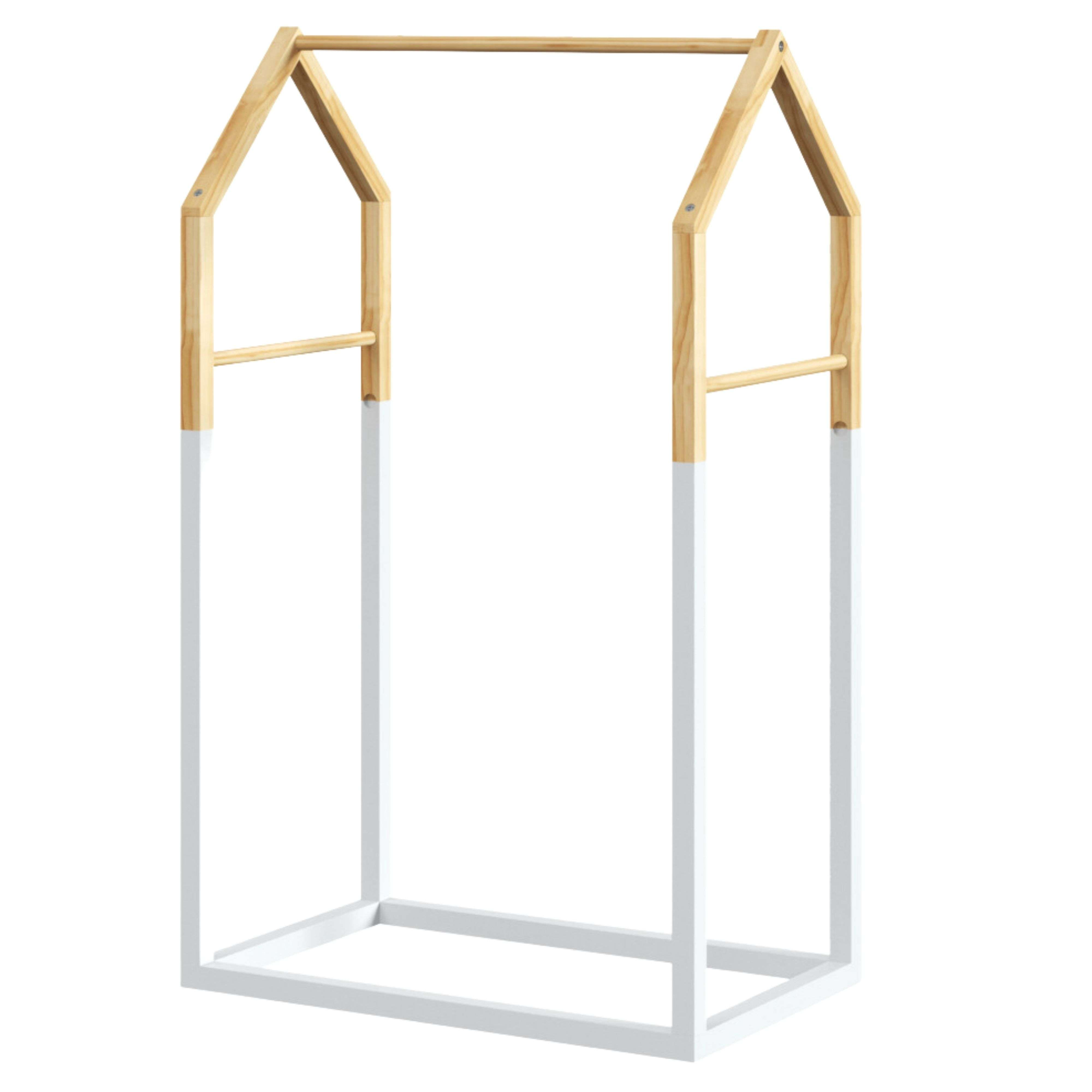 Una estructura de madera con forma de casa, patas blancas y barra de ropa.
