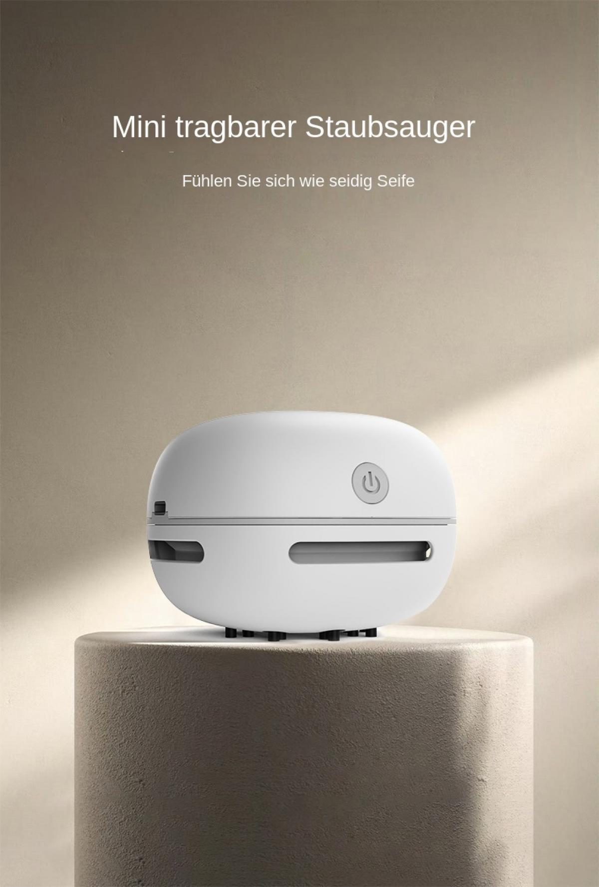 Ein weißer, tragbarer Mini-Staubsauger mit einem Power-Button steht auf einem grauen Podest.