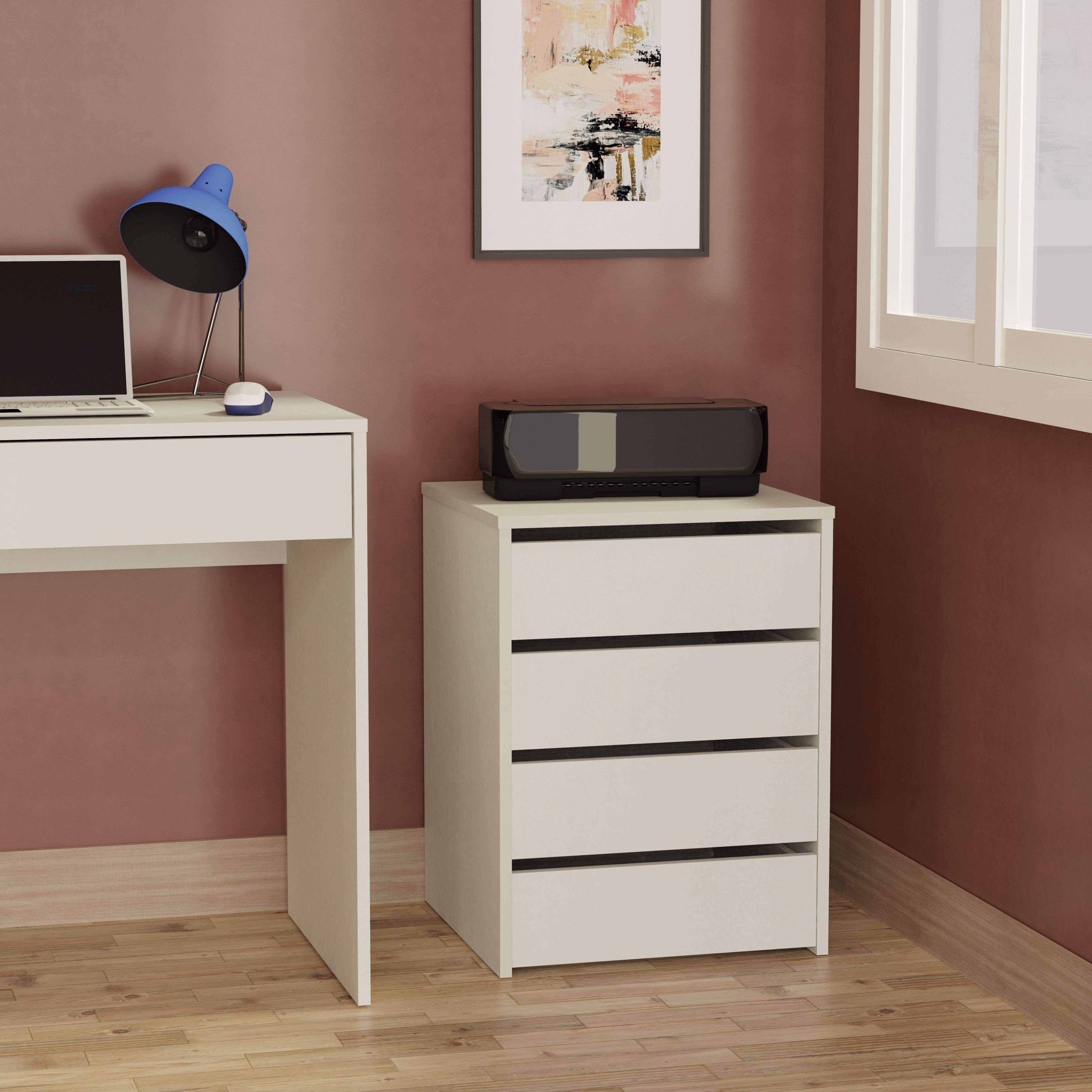 Un escritorio blanco con portátil y lámpara, junto a un mueble blanco con impresora.