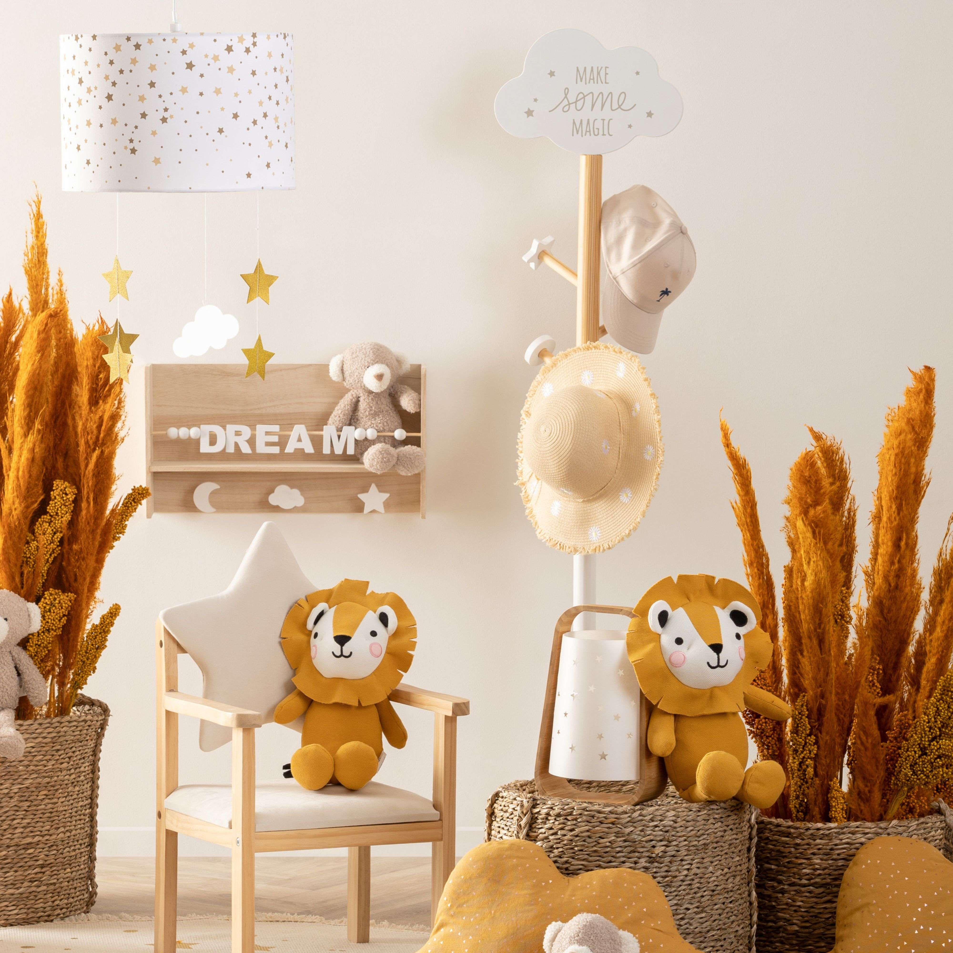 Una guardería con dos cojines de león, un osito de peluche y flores secas.