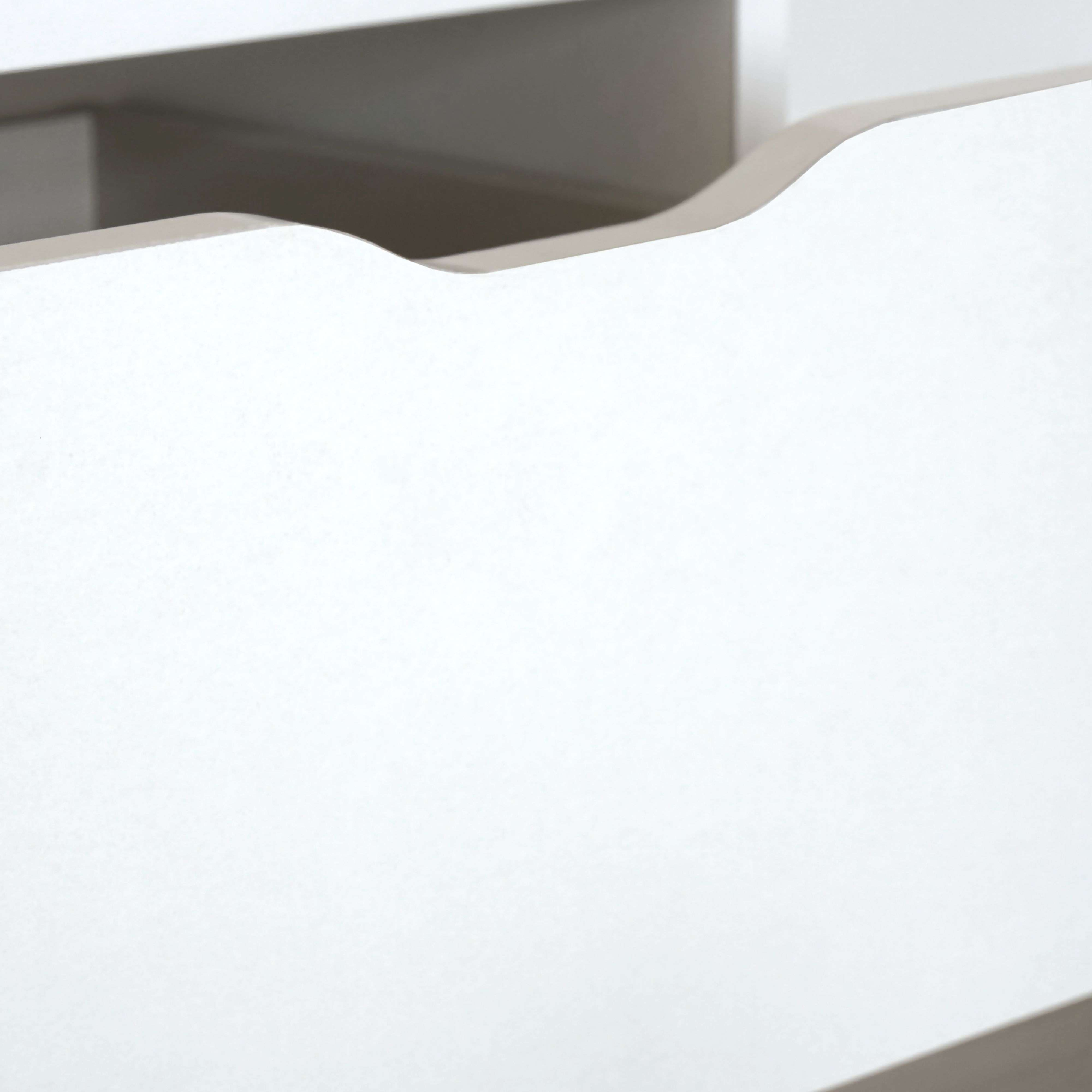 Un primer plano de un cajón blanco con una sombra oscura.