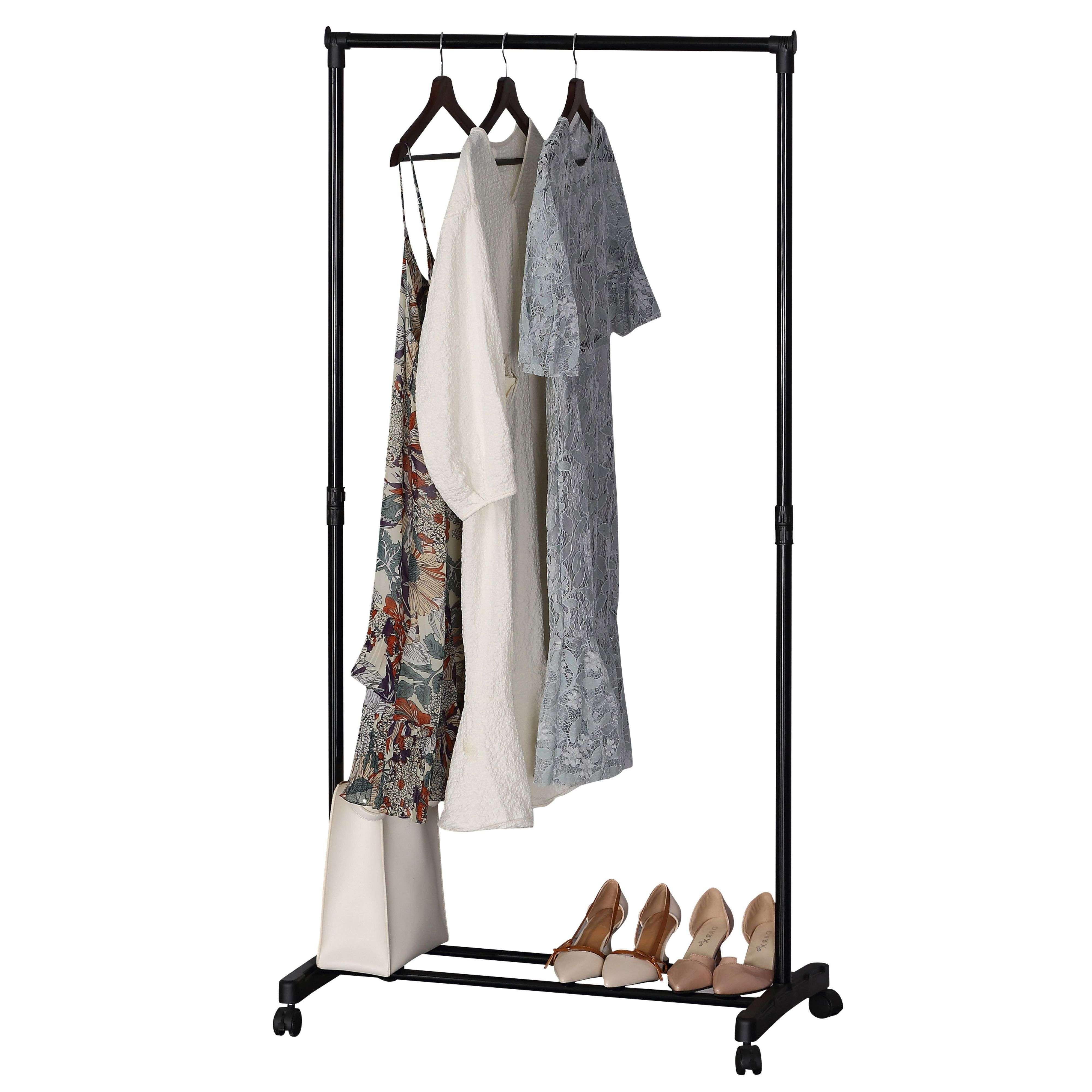 Perchero con vestidos, bolso y zapatos sobre fondo blanco.