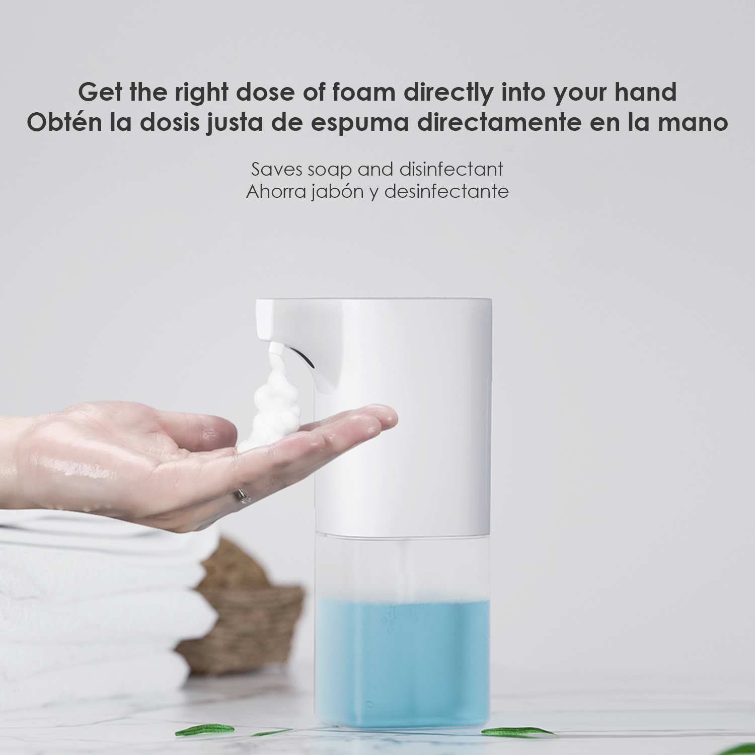 Dispensador automático de jabón que da espuma en una mano. Líquido azul abajo.