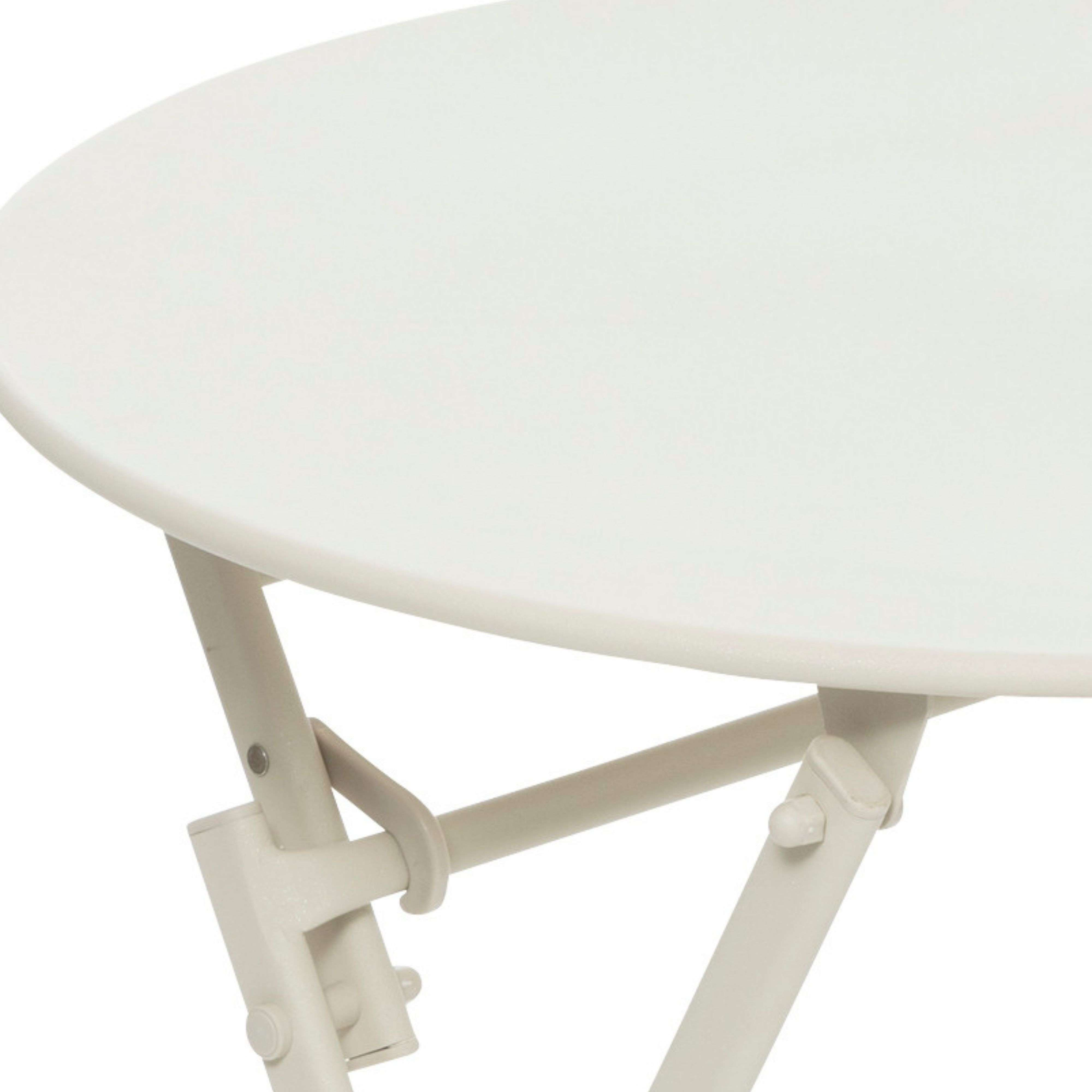 Una mesa redonda blanca con patas de metal, vista de cerca.
