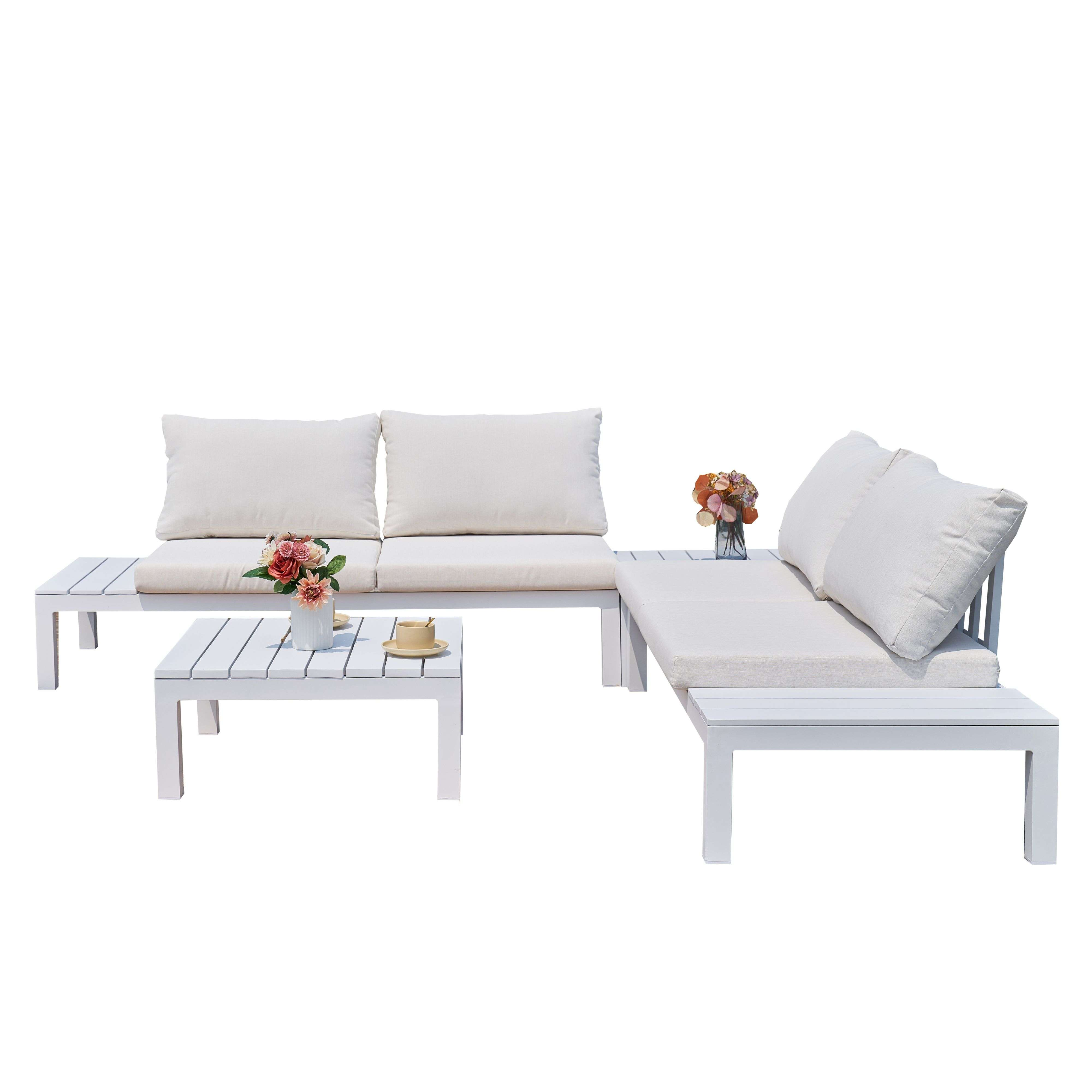 Conjunto de sofá blanco para exterior con cojines crema, mesa de centro con flores.