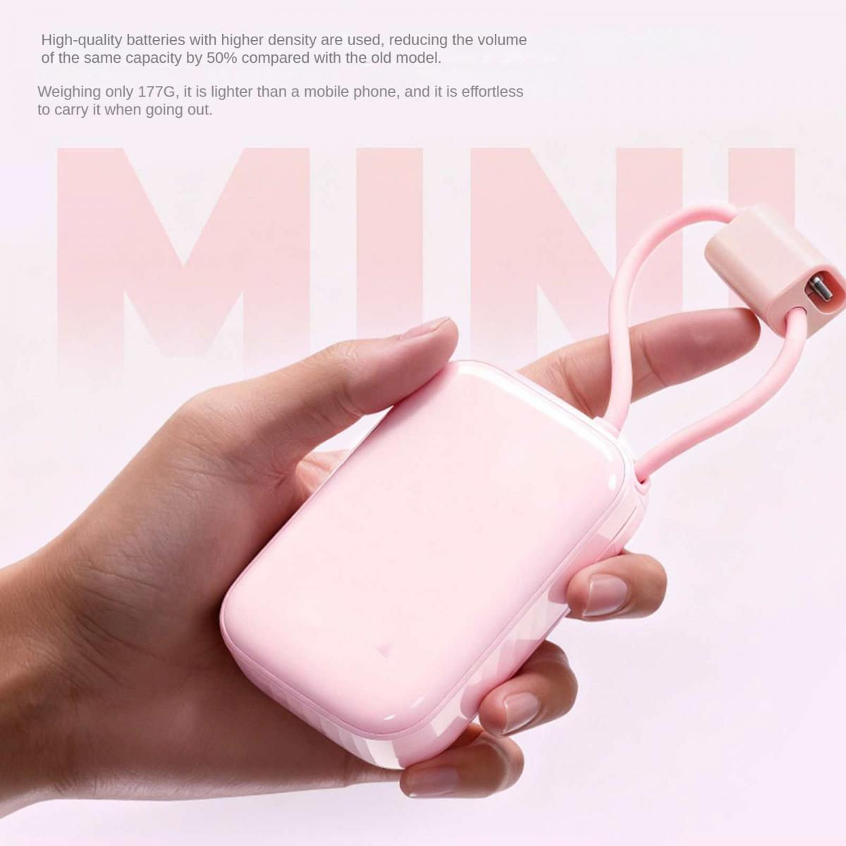 Eine Hand hält ein kleines, hellrosa Powerbank-Gerät mit einem Ladekabel.