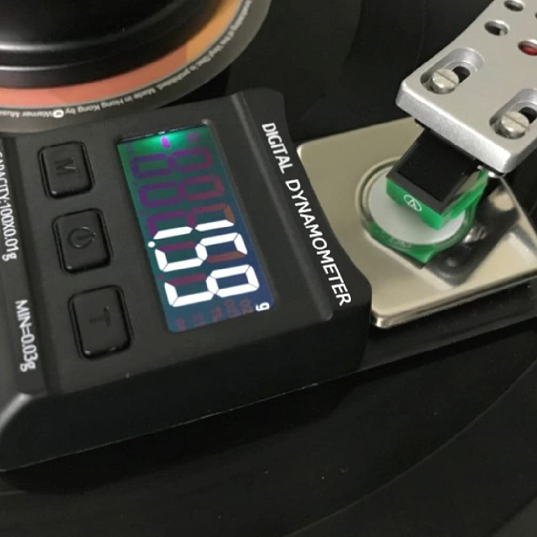 Un dinamometro digitale misura 1,9 g su un giradischi.