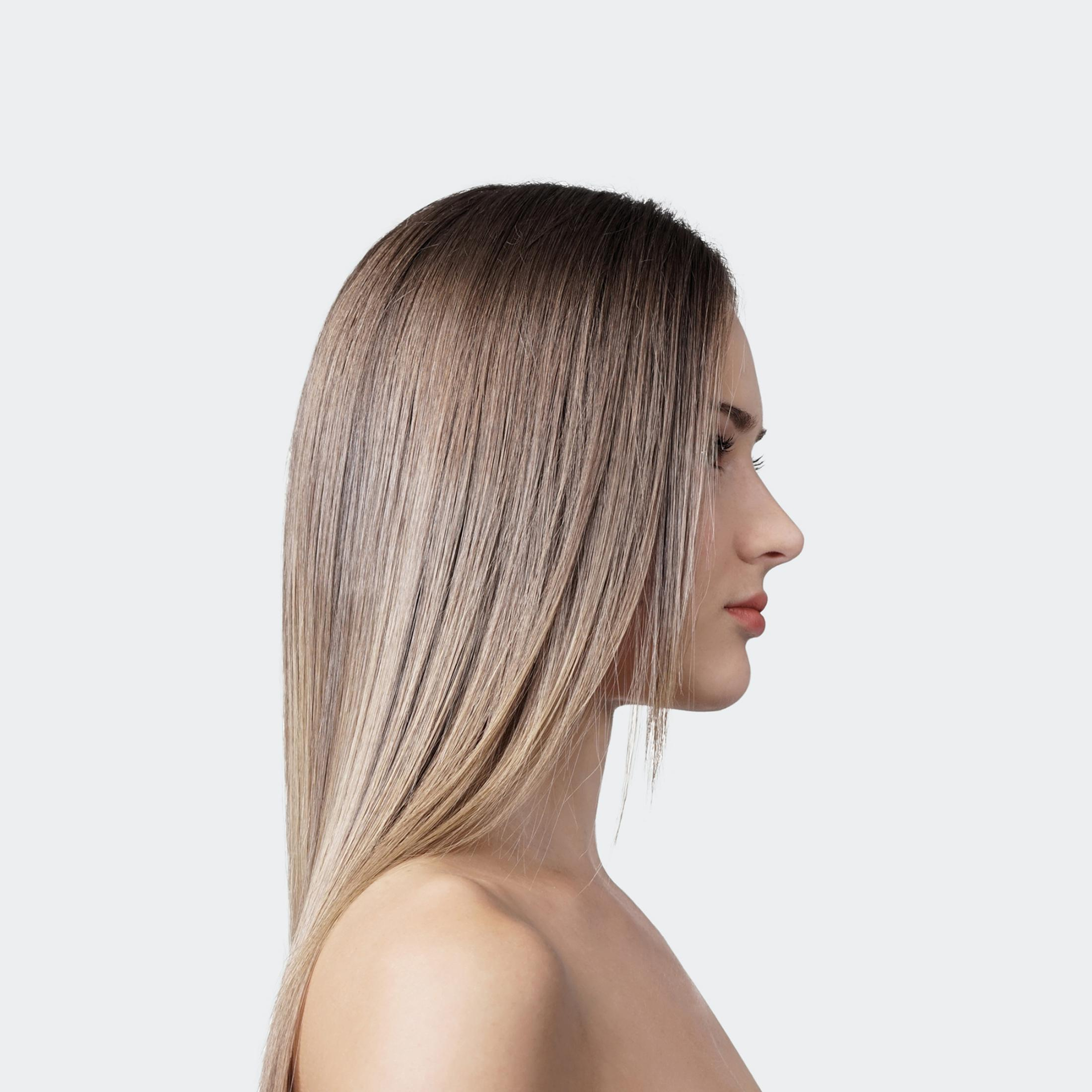 Profiel van vrouw met lang blond haar tegen lichte achtergrond.