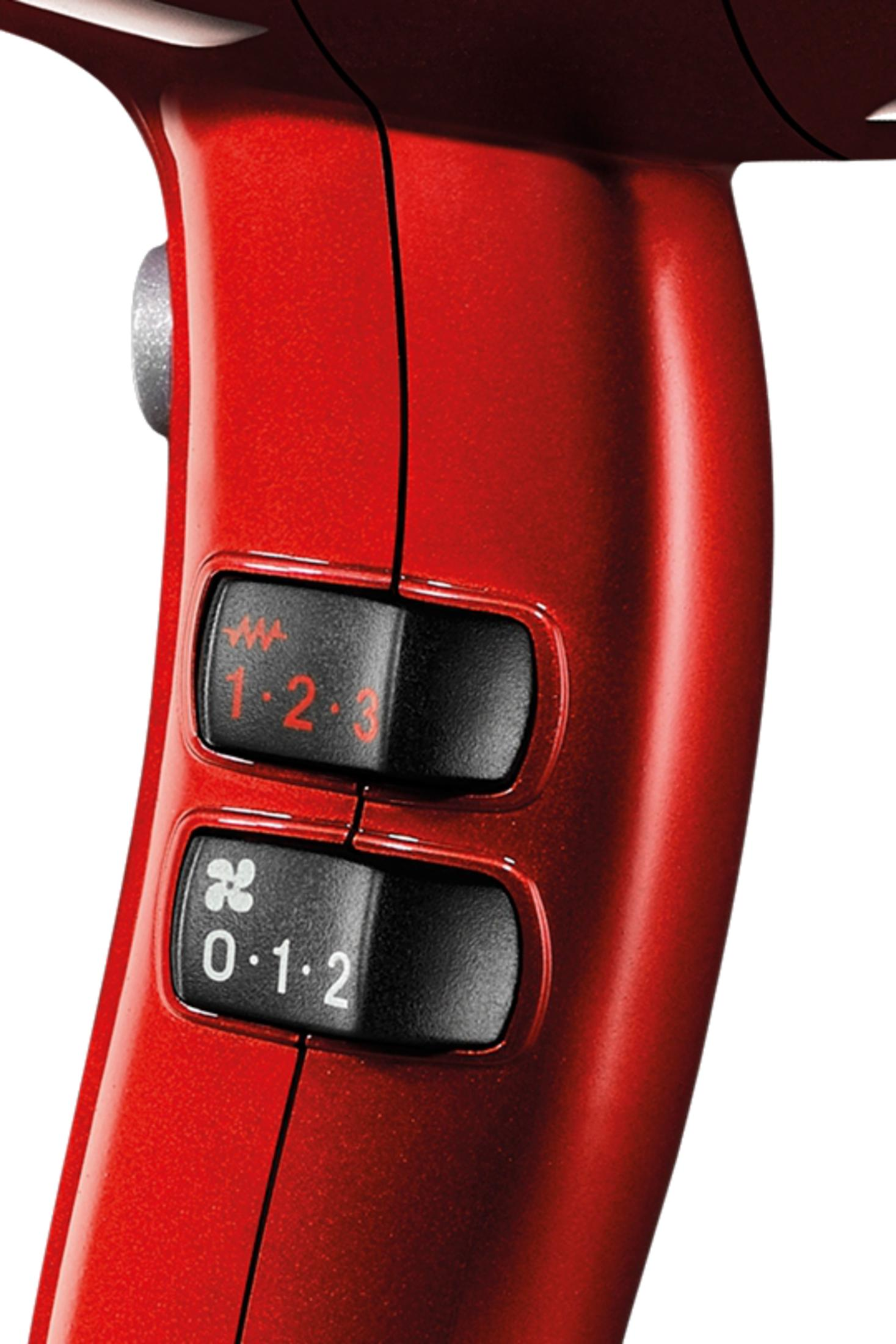 Asciugacapelli rosso con interruttori neri per velocità e calore.
