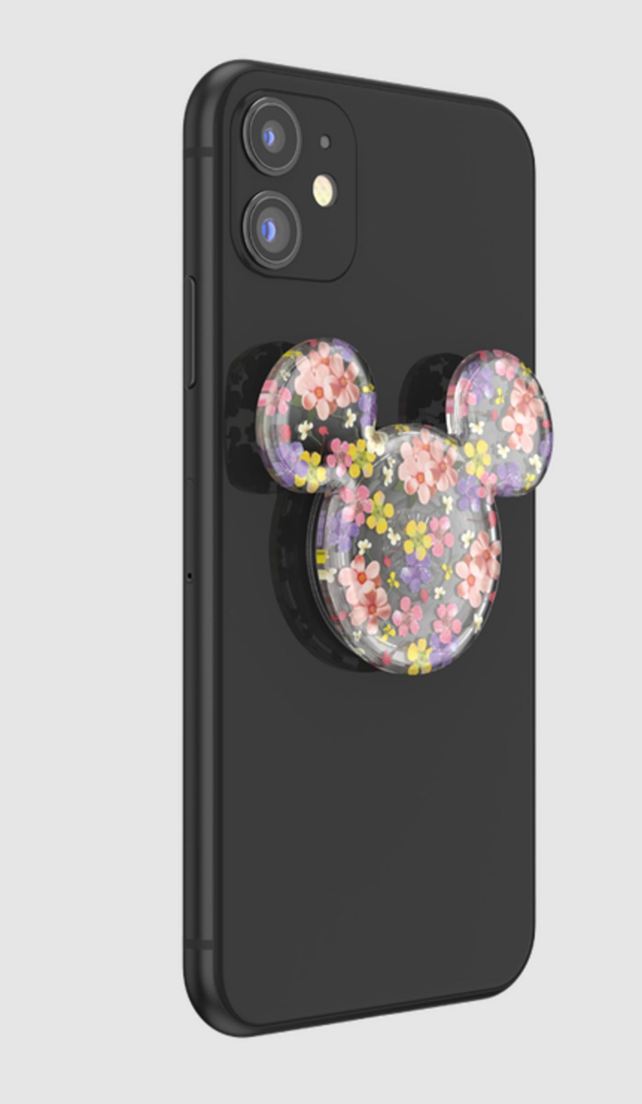 Un iPhone nero con un accessorio a forma di Topolino floreale.