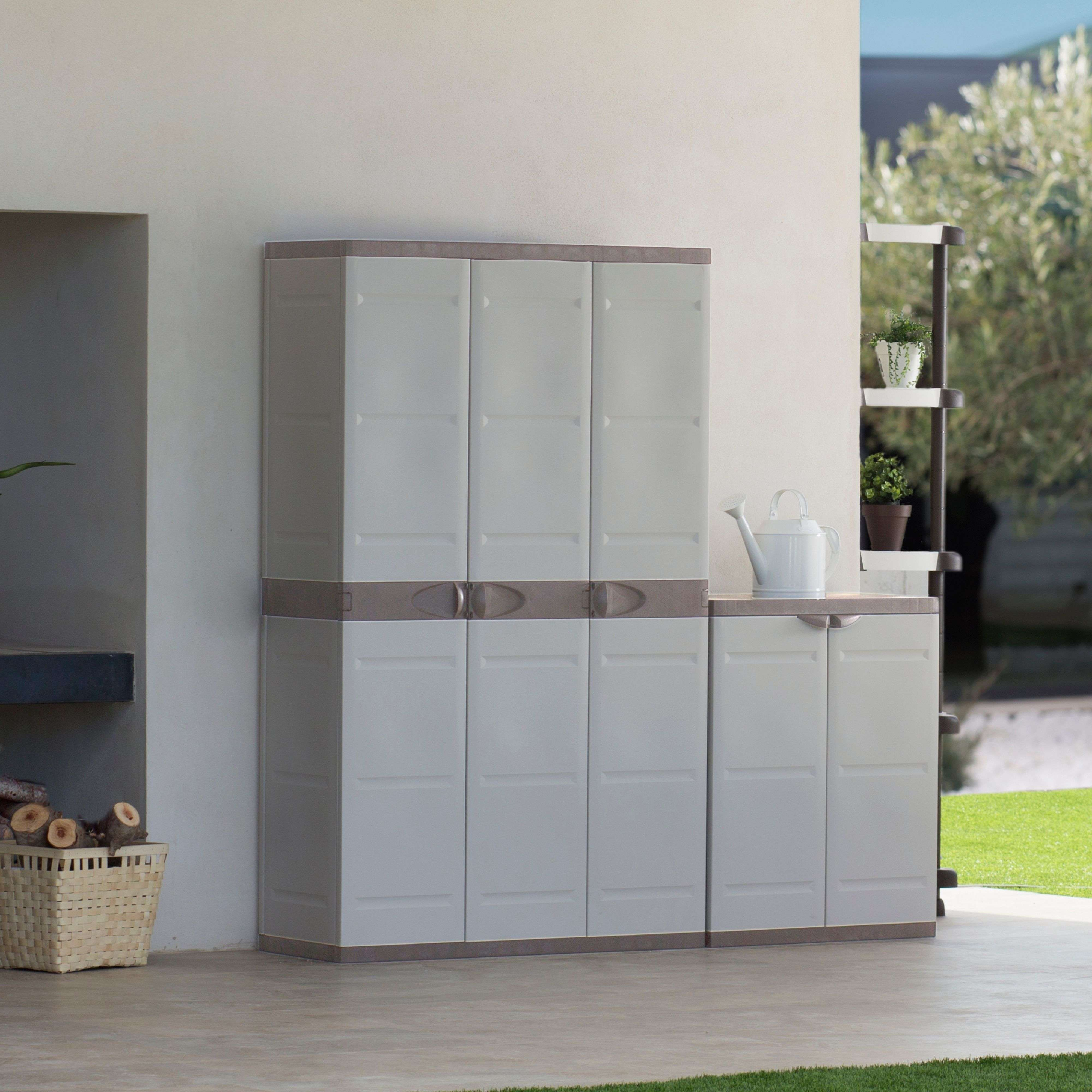 Un armario blanco de exterior con cuatro puertas, junto a un armario más pequeño con una puerta.