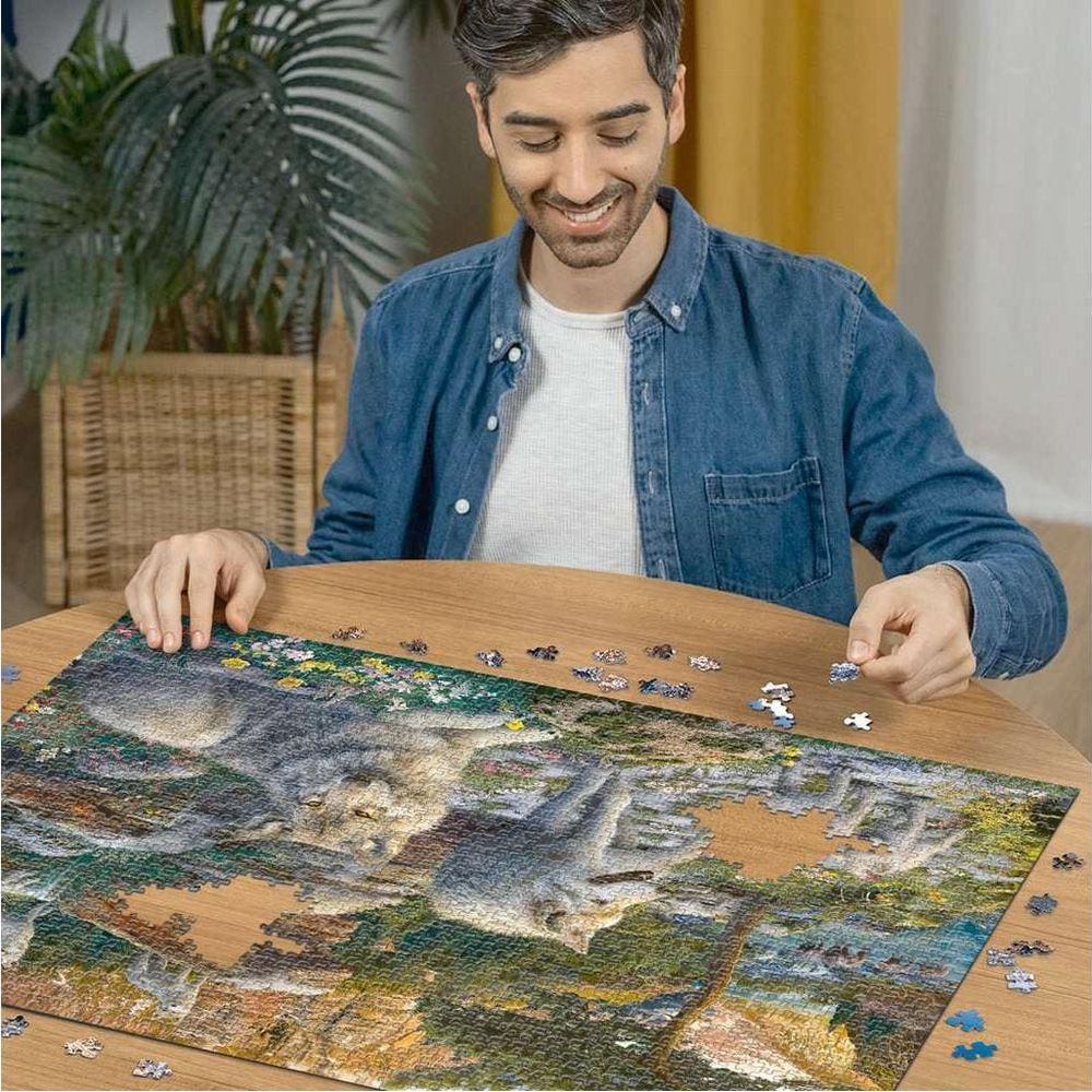 Uomo che assembla un puzzle di lupi su un tavolo di legno. Pezzi sparsi.
