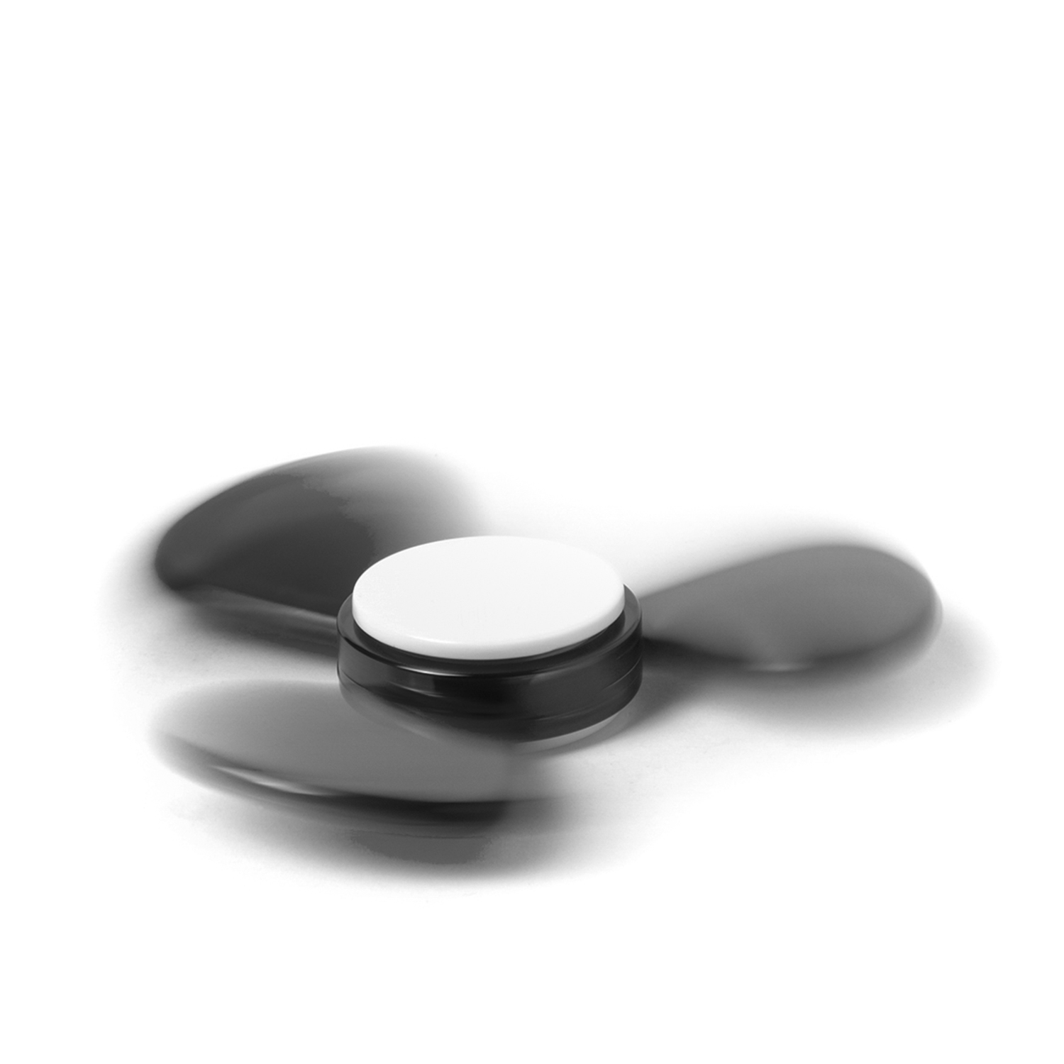 Un spinner de fidget negro con centro blanco gira sobre fondo blanco.