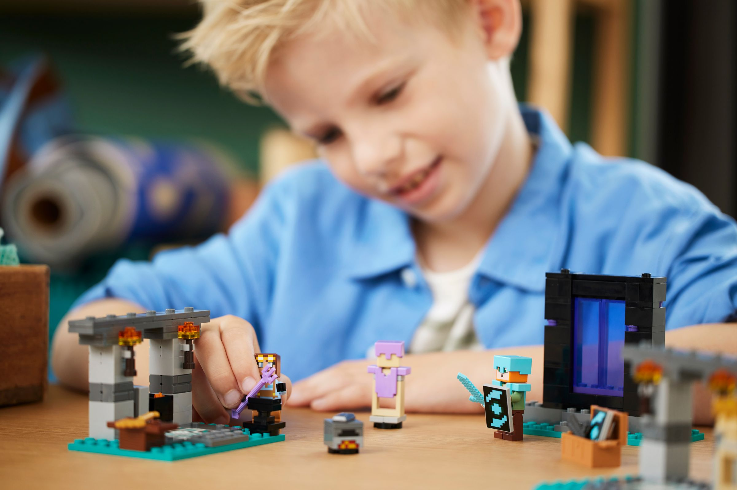 Ein Junge spielt mit Minecraft-Spielzeugfiguren und einem Portal-Set.