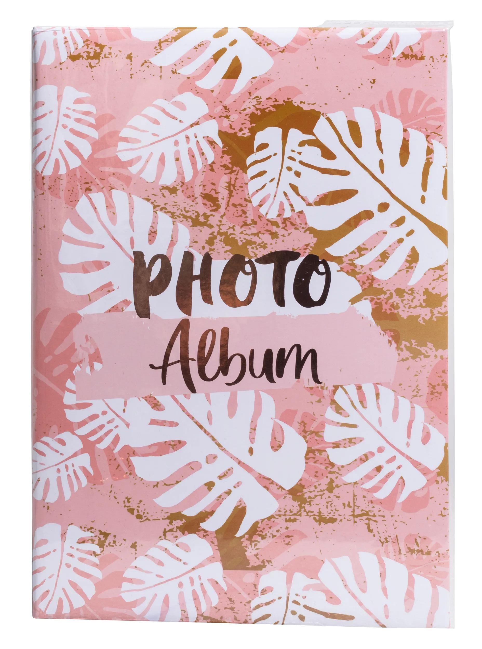 Un album fotografico rosa con foglie di monstera bianche e texture dorata.