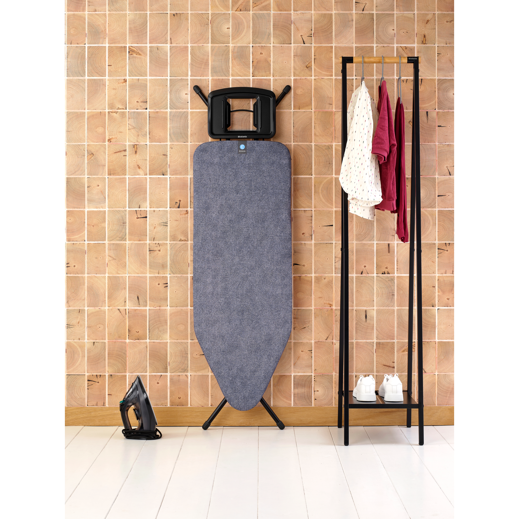 Fer à repasser, planche à repasser, portant à vêtements avec linge et chaussures.