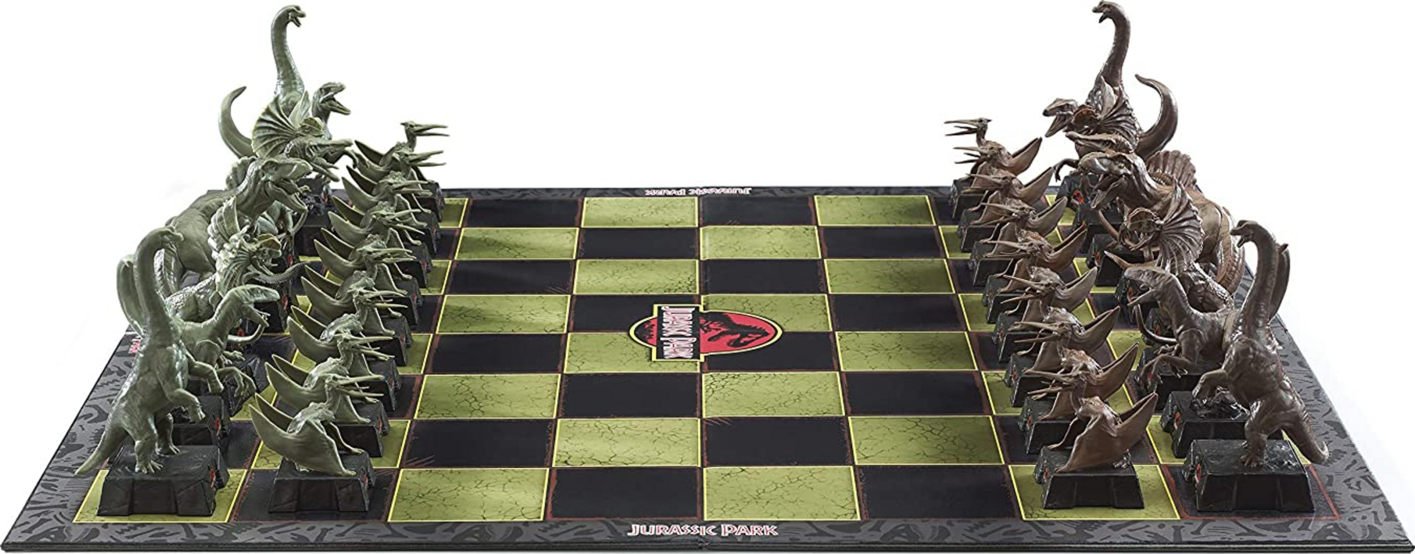 Un juego de ajedrez de Jurassic Park con figuras de dinosaurios en un tablero verde y negro.
