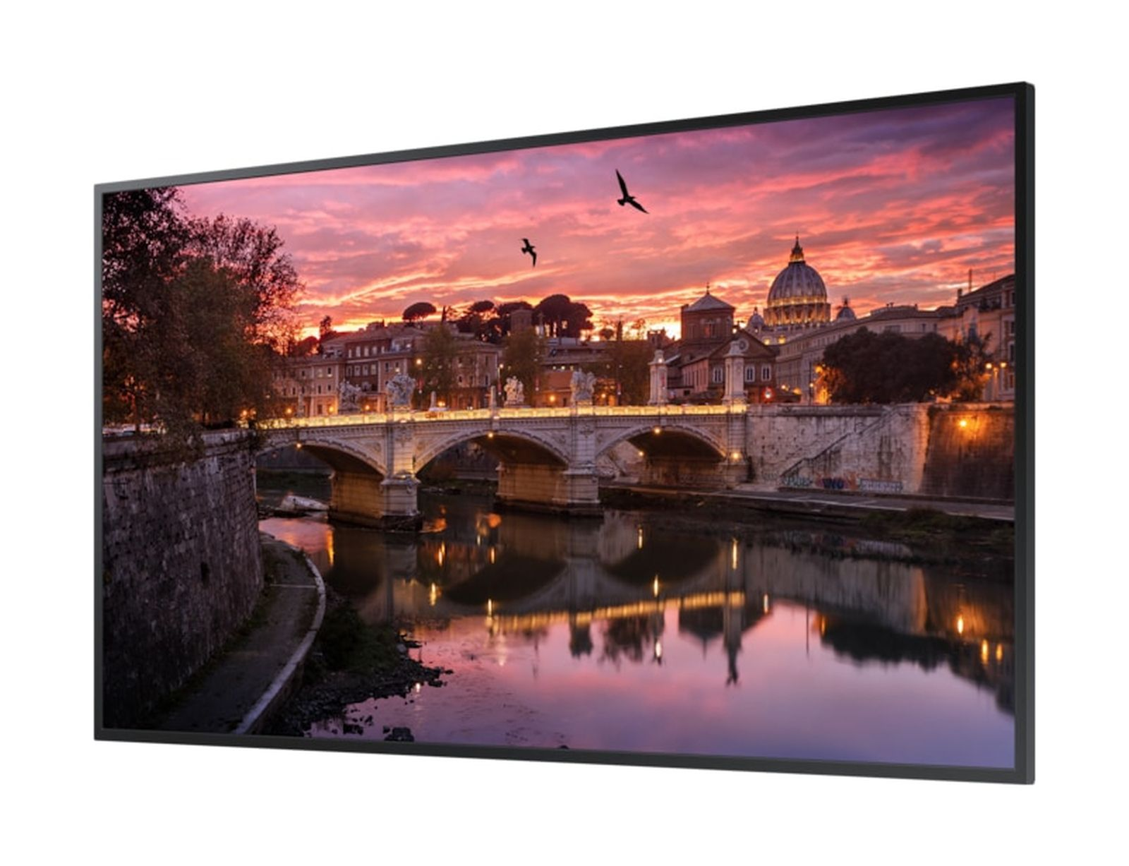 Eine Brücke überspannt einen Fluss bei Sonnenuntergang mit der Kuppel von St. Peter im Hintergrund.