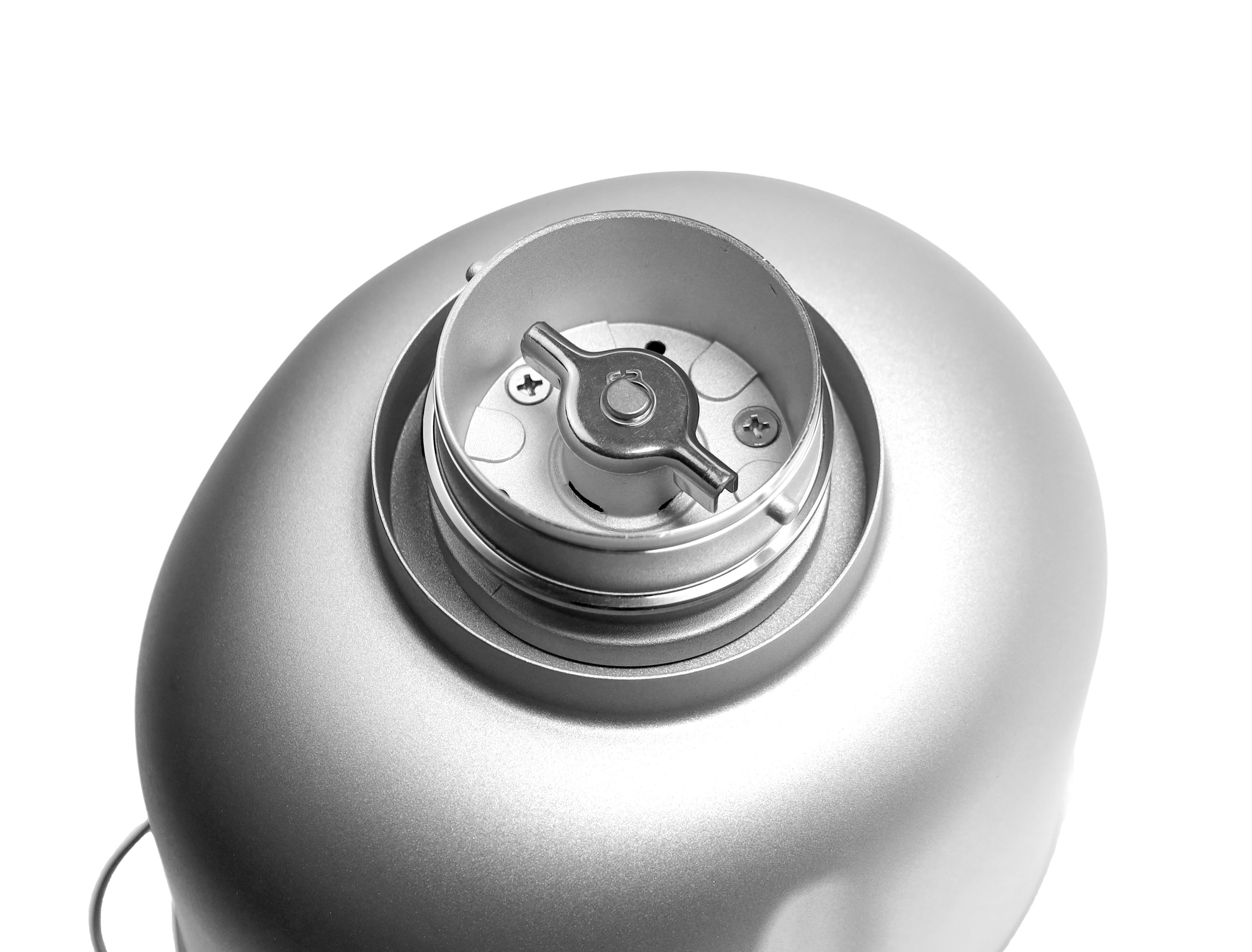 Nahaufnahme eines silbernen Geräts mit einem metallischen Drehknopf oben.