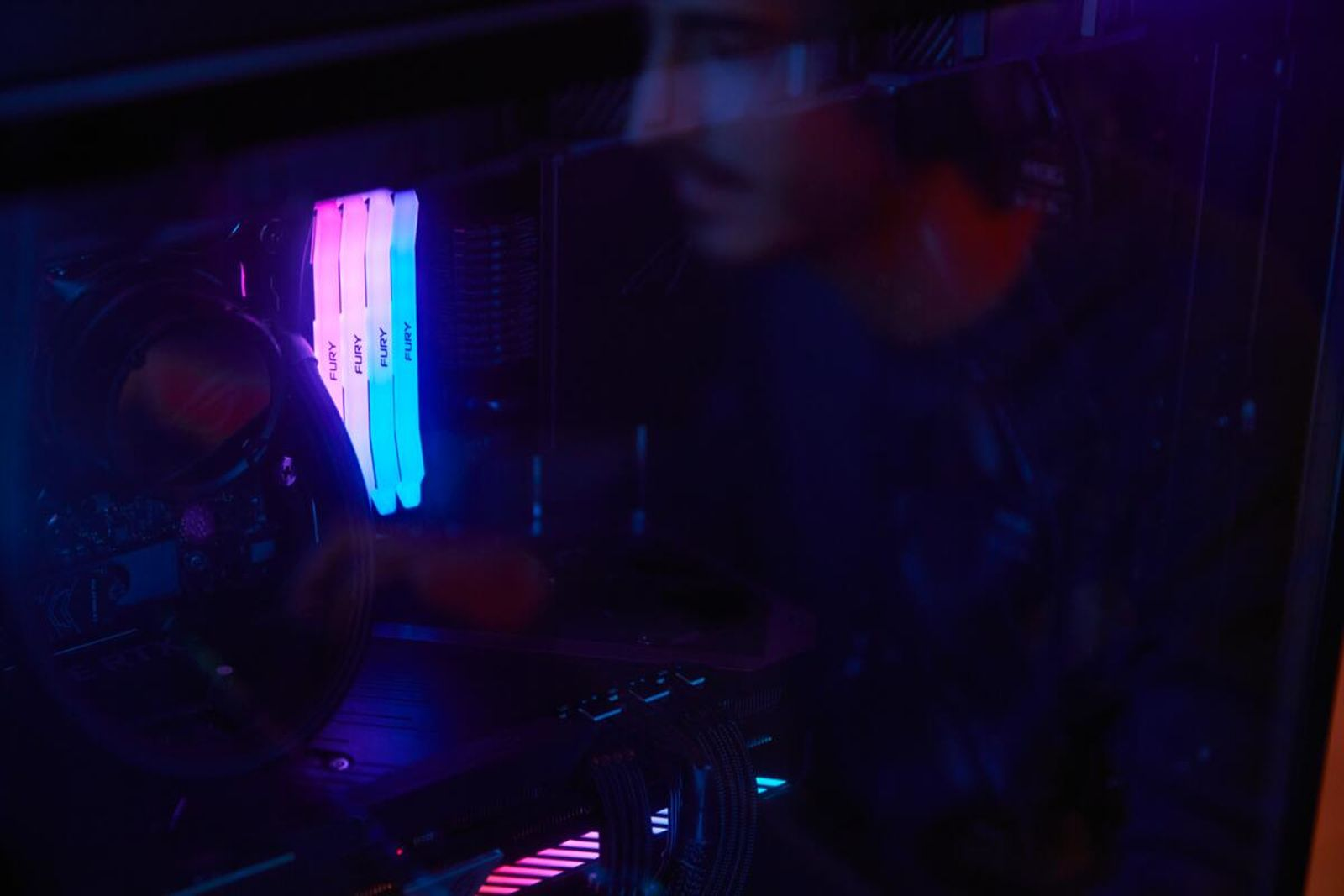 Obudowa komputera z podświetlanymi modułami RAM w kolorach różowym i niebieskim.