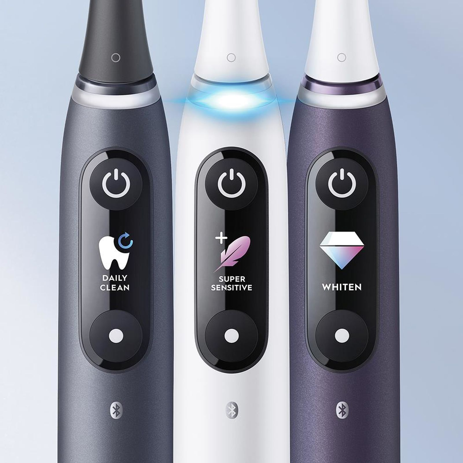 Tre spazzolini elettrici grigi, bianchi e viola, che mostrano modalità diverse.