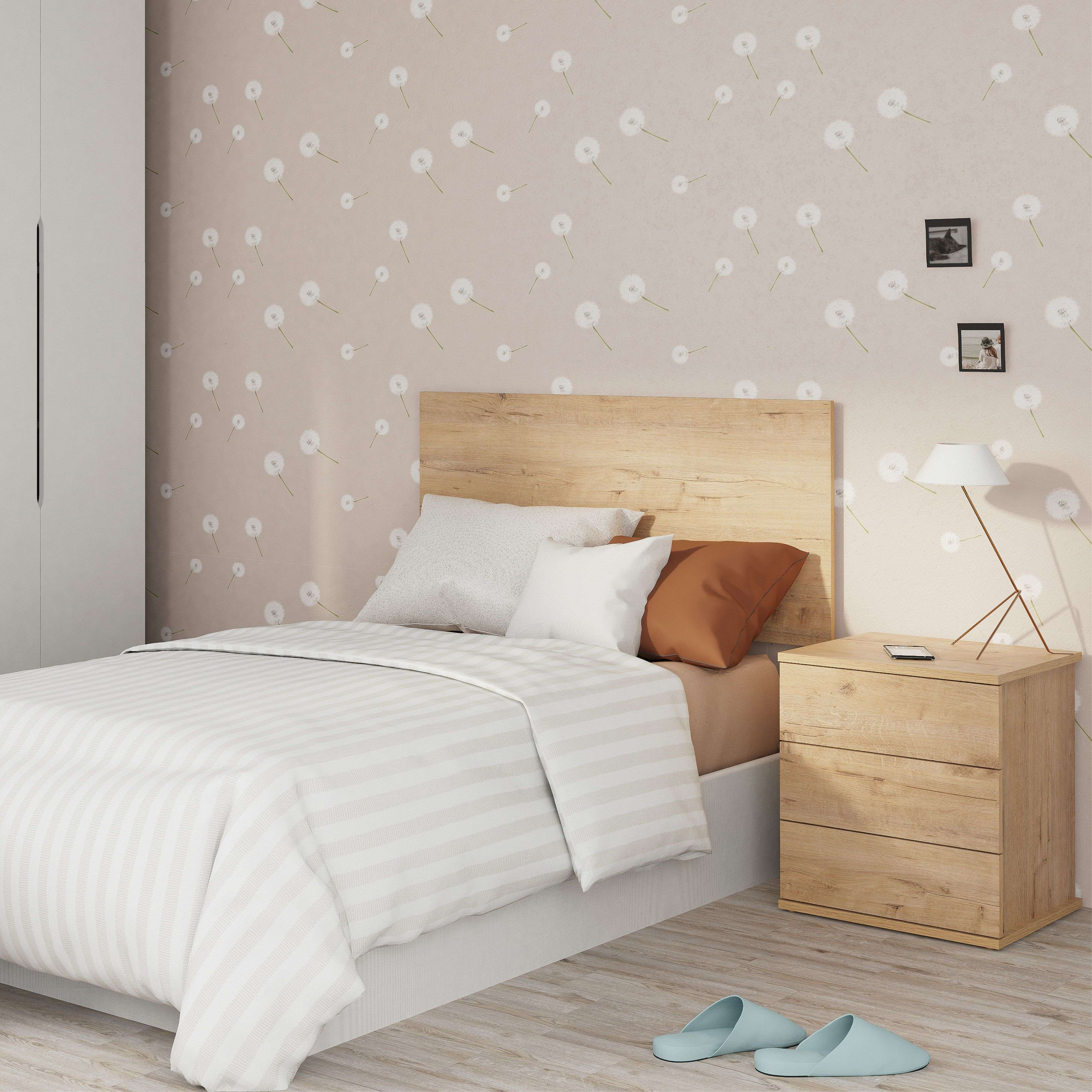 Un dormitorio con cama, mesita de noche, lámpara, armario y cuadros en la pared.