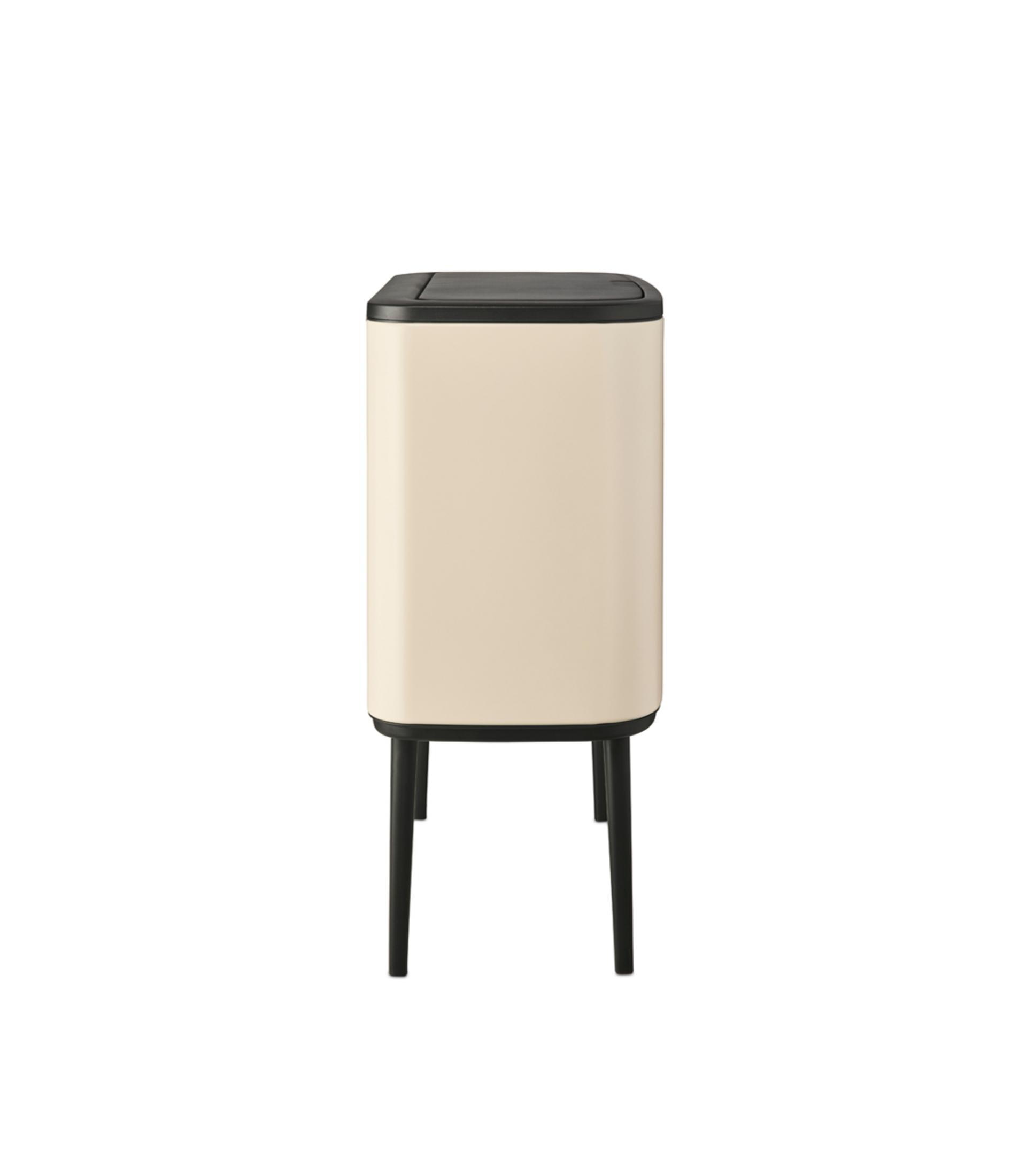 A cream-colored rectangular trash can with a black lid and legs.