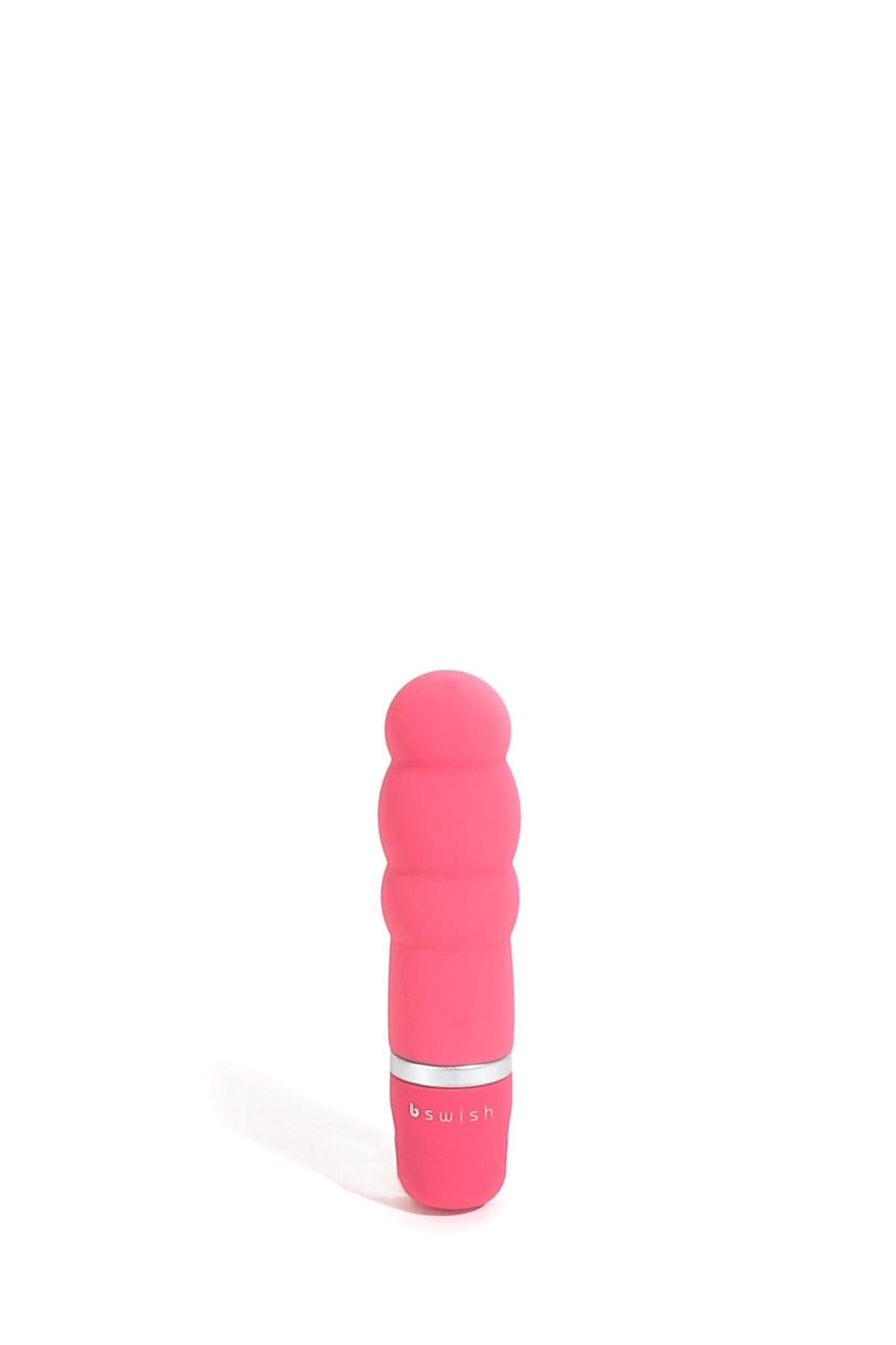 Un vibrador pequeño y rosa con superficie acanalada y anillo plateado.