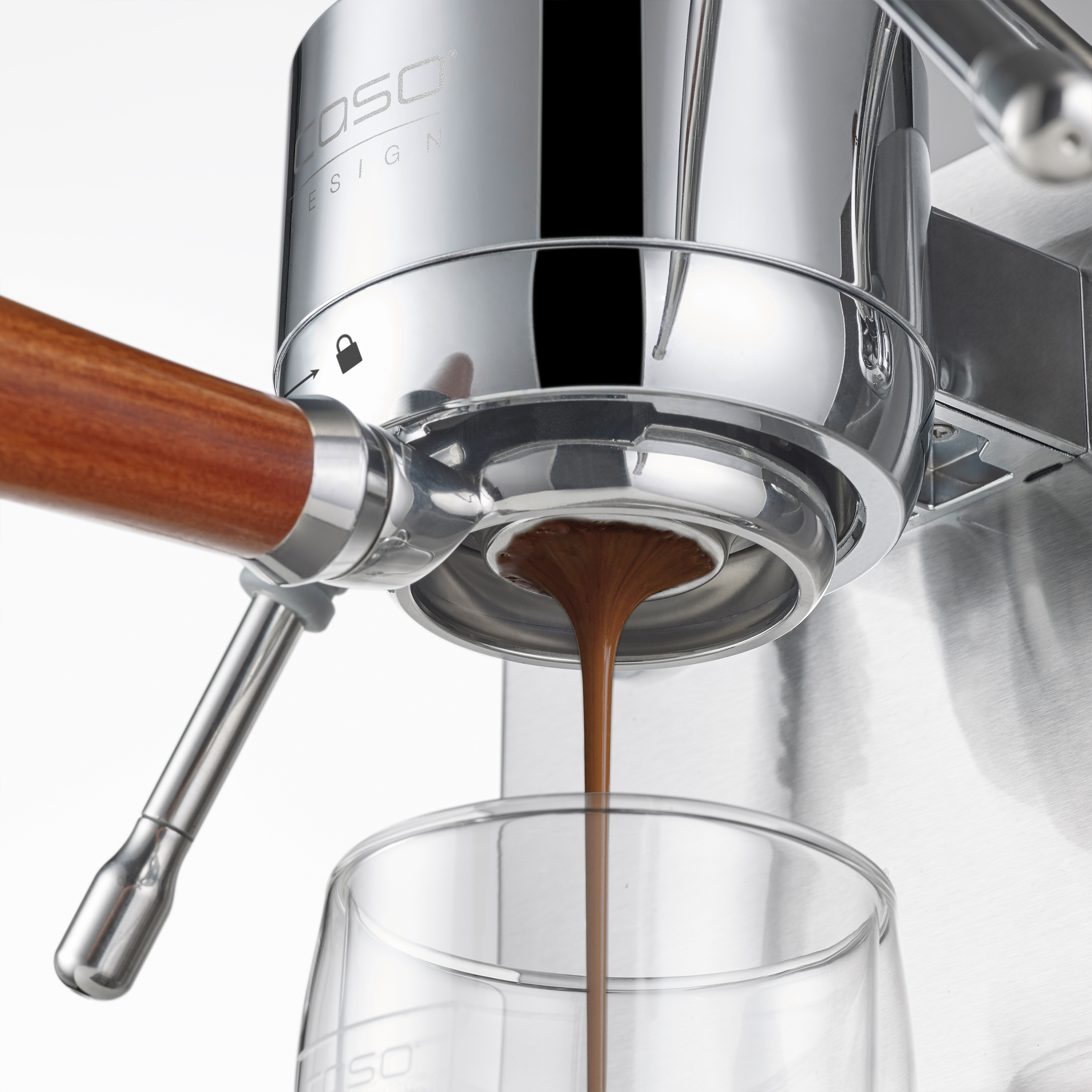 Espressomaschine brüht Kaffee in ein Glas. Holzgriff und Chromdetails.