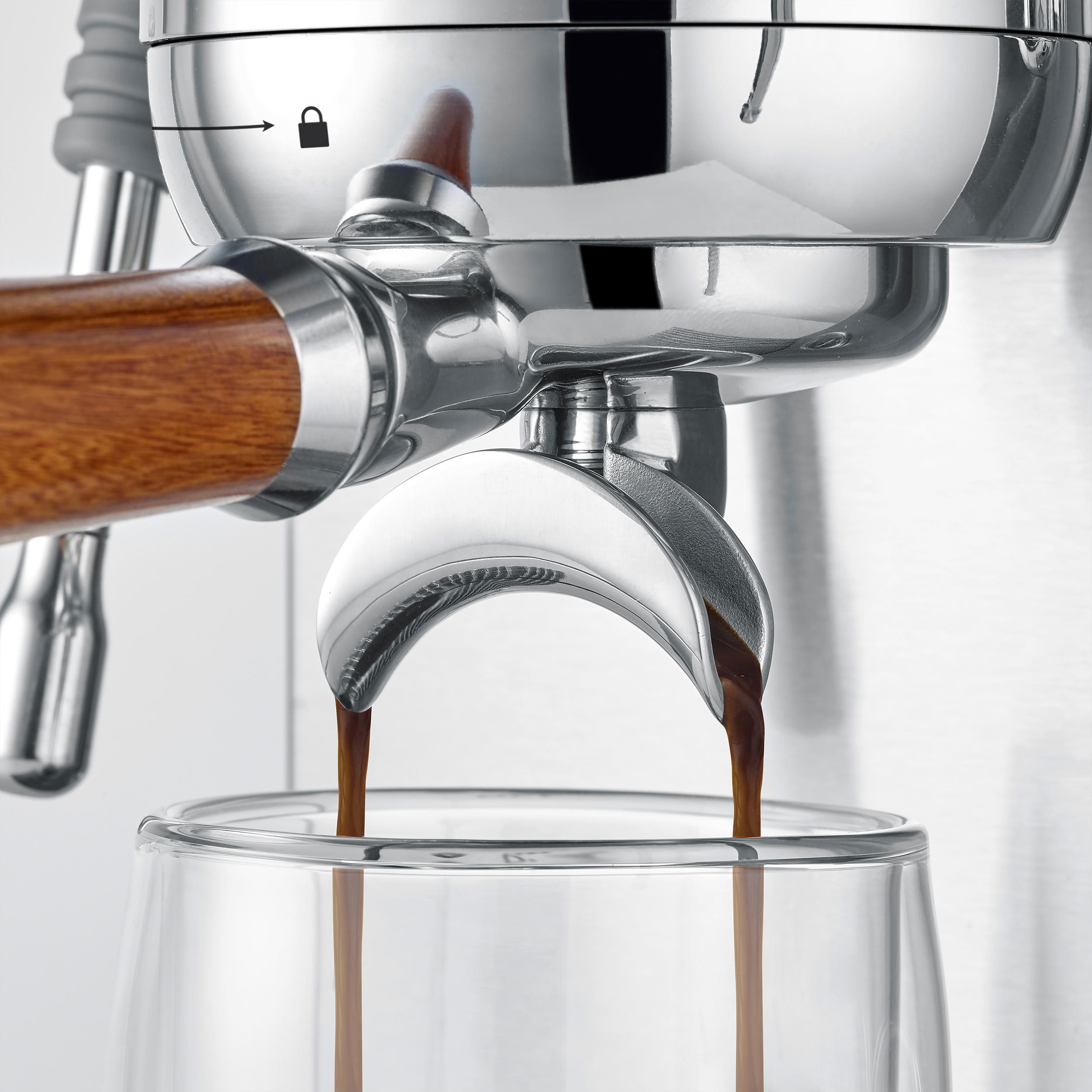 Espressokaffee fließt aus einer Kaffeemaschine in ein Glas.