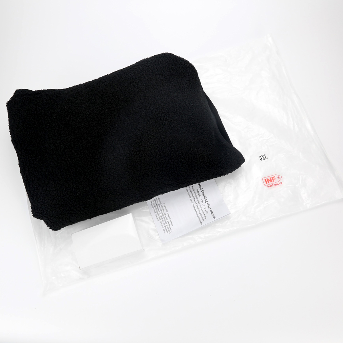 Czarny polarowy sweter w opakowaniu foliowym z instrukcją obsługi i metką rozmiaru 3XL.