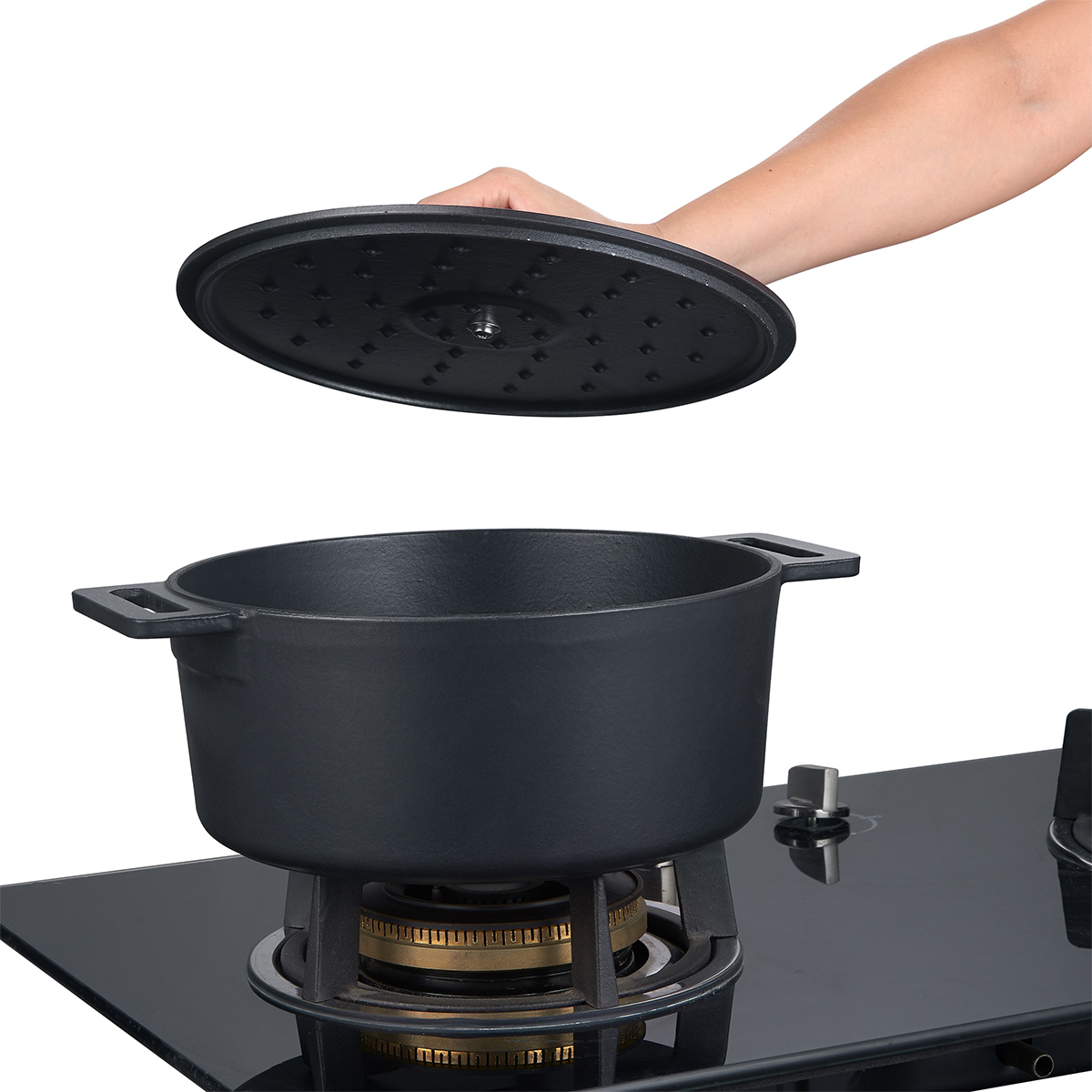 A hand holds a black cast iron pot lid over a pot on a gas stove.