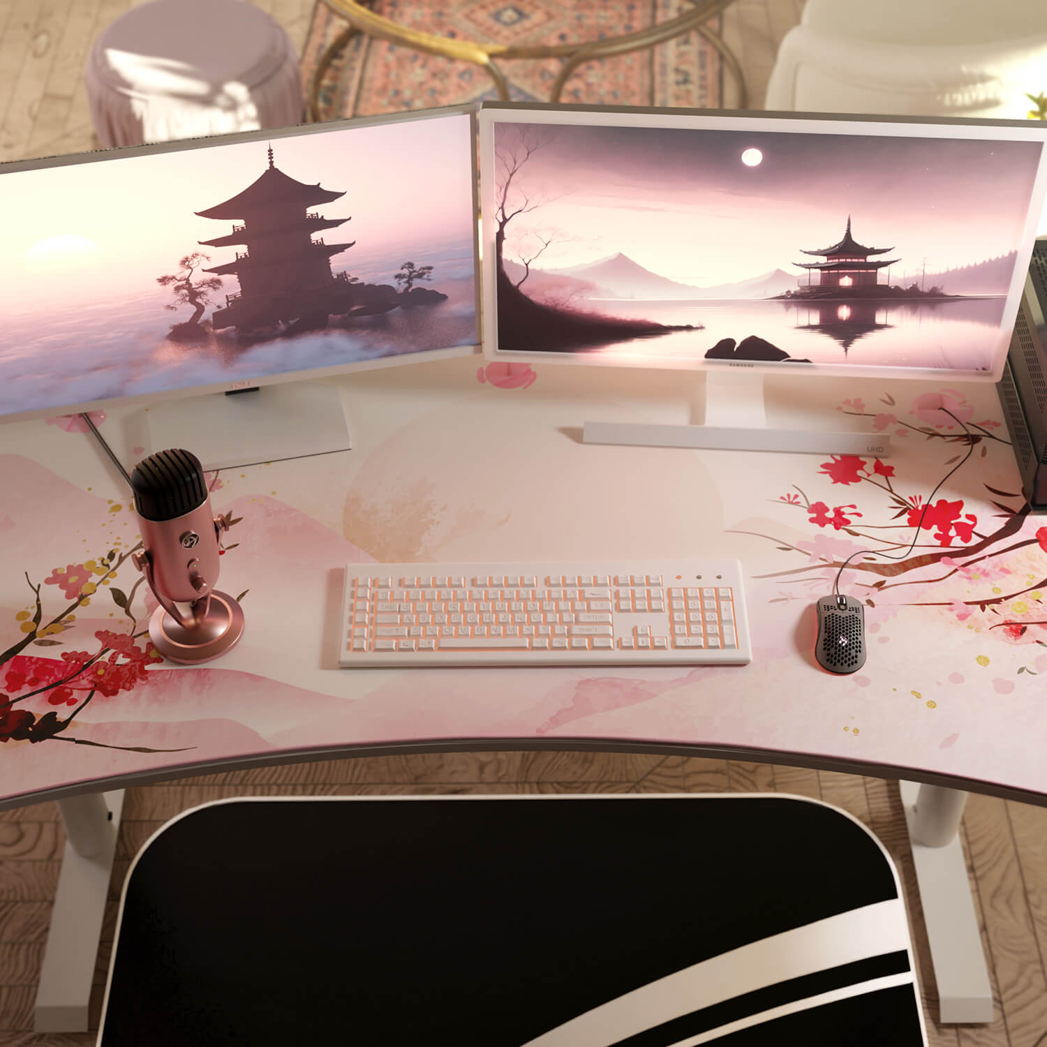 Una scrivania con due monitor, tastiera, mouse e microfono con accenti floreali.