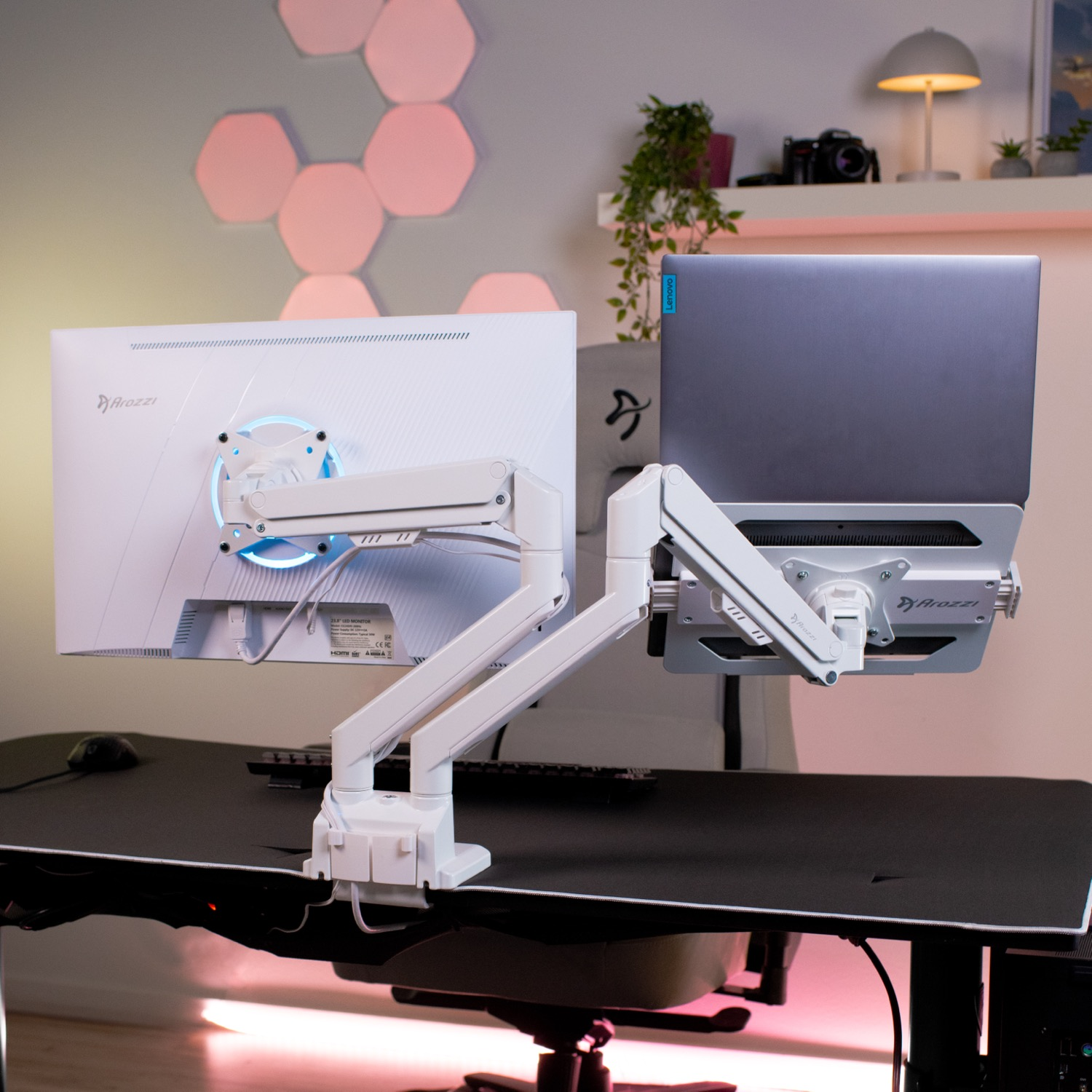 Dual monitor bureau-opstelling met witte armen die een monitor en laptop vasthouden.